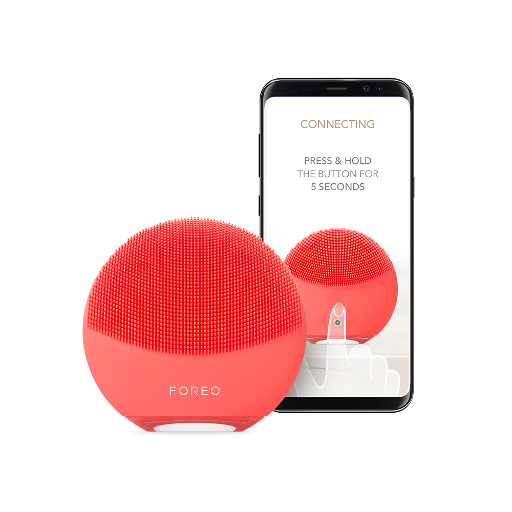 Appareil Foreo rouge à côté d'un écran de téléphone affichant un appareil similaire.