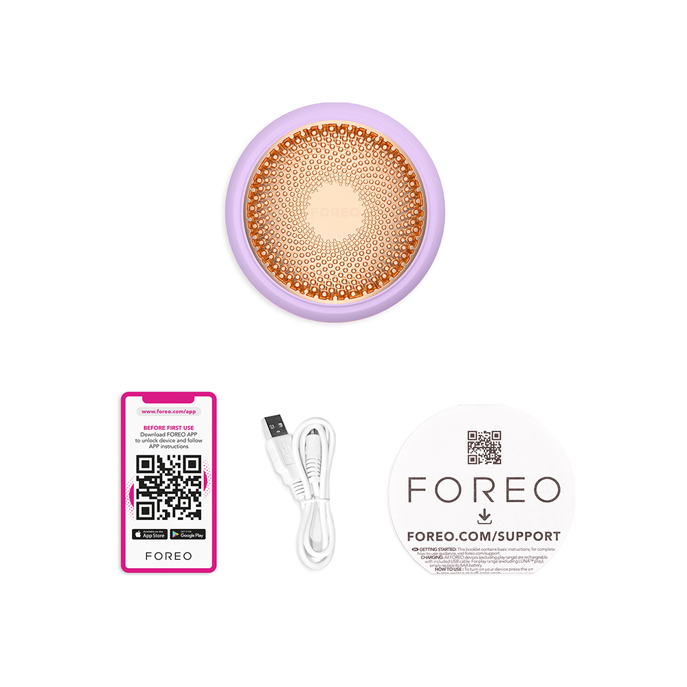 Foreo-apparaat, app-downloadinstructies en een USB-kabel op een wit oppervlak.