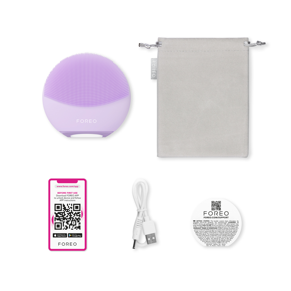 Lavender FOREO device, charging cable, soft pouch, instruction card and app instructions on white.