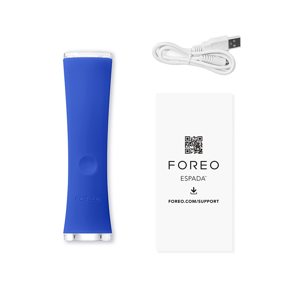 Mavi FOREO cihazı, USB kablosu ve talimatlar. Beyaz arka plan. FOREO ESPADA metni ve QR kodu.