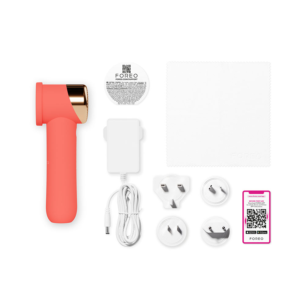 Coral beauty device with accessories, including adapters and a cleaning cloth, on a white surface.