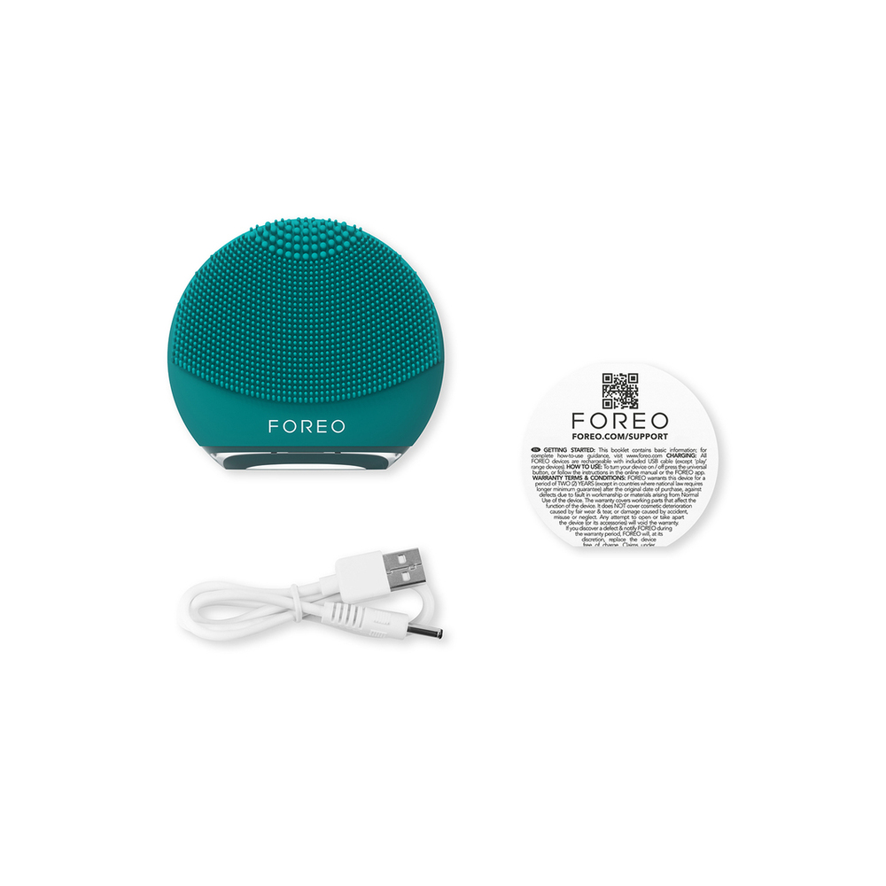 Teal facial cleansing device with accessories: cable, instructions.