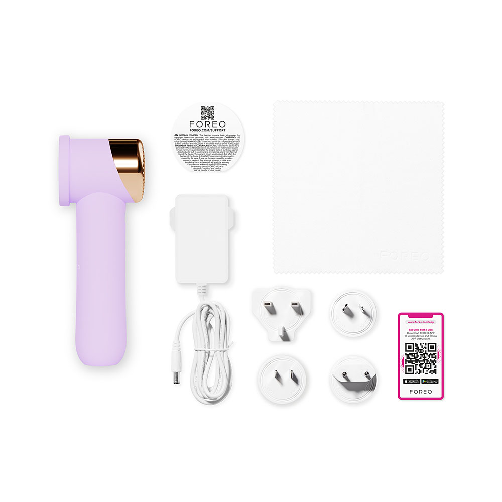 Flat lay of Foreo device, charger, plugs, cleaning cloth, and QR code card. White background.