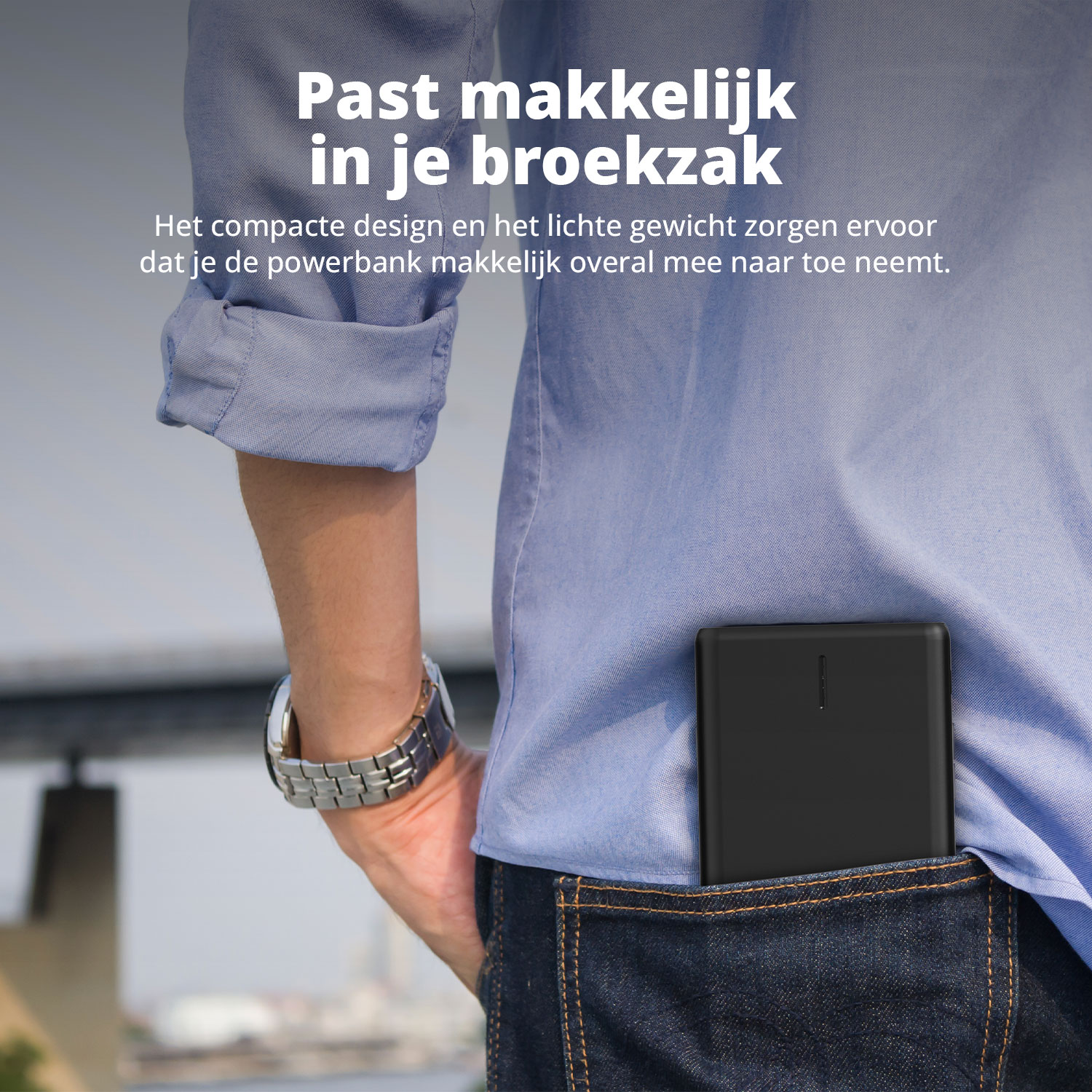 Man met horloge, powerbank in jeanszak, zwart overhemd. Tekst: Past makkelijk in je broekzak.