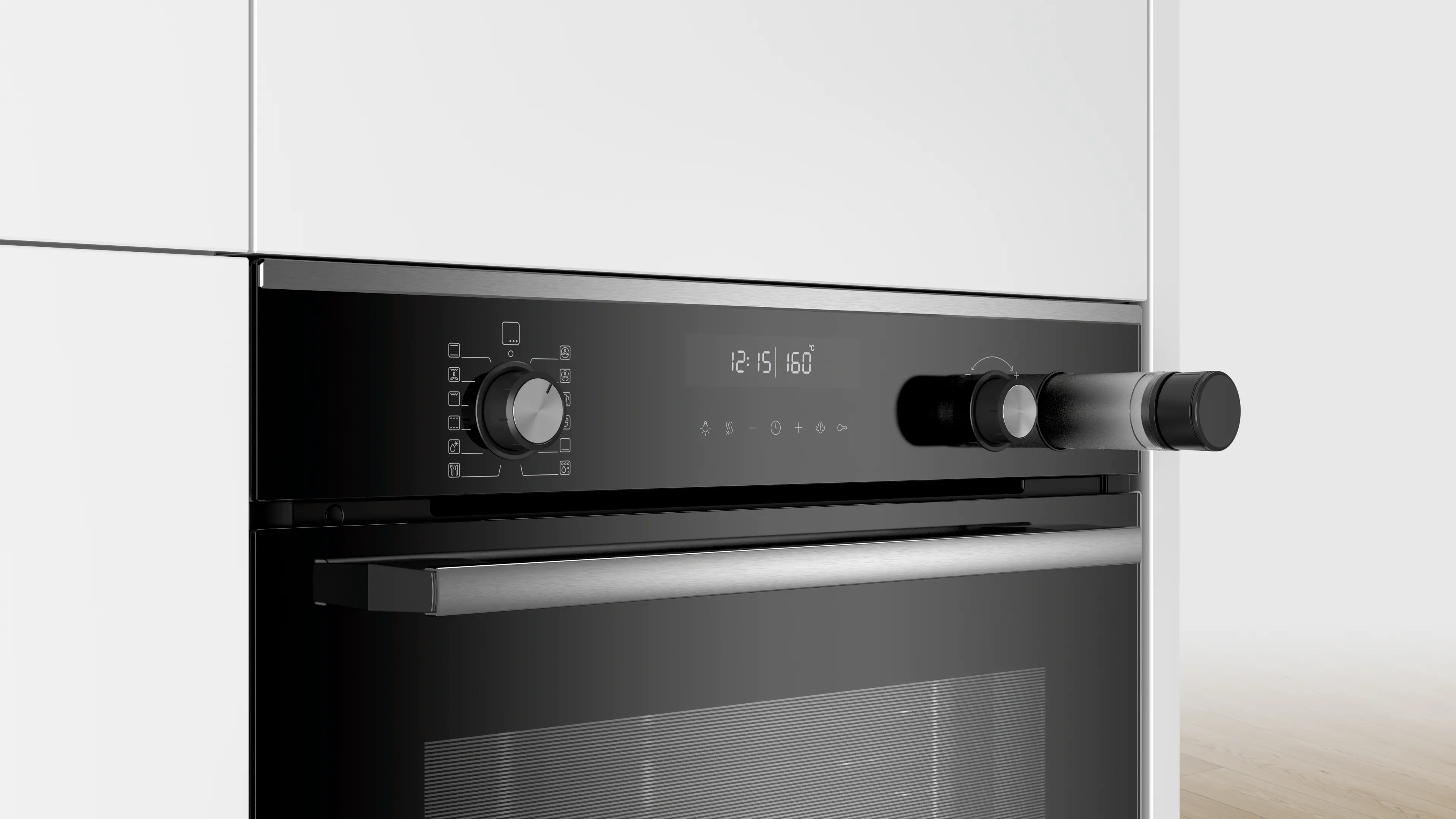 Primo piano di un forno nero con display digitale e maniglia in acciaio inox, in mobili bianchi.