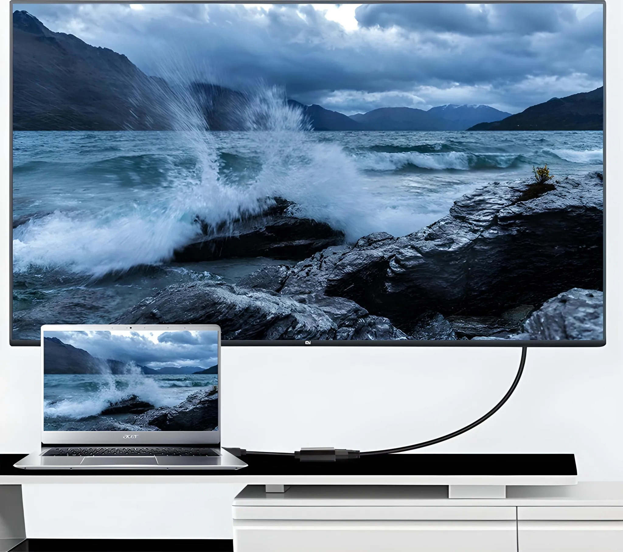 Laptop und Fernseher, die ein landschaftliches Bild zeigen, verbunden durch ein Kabel auf weißem Ständer.