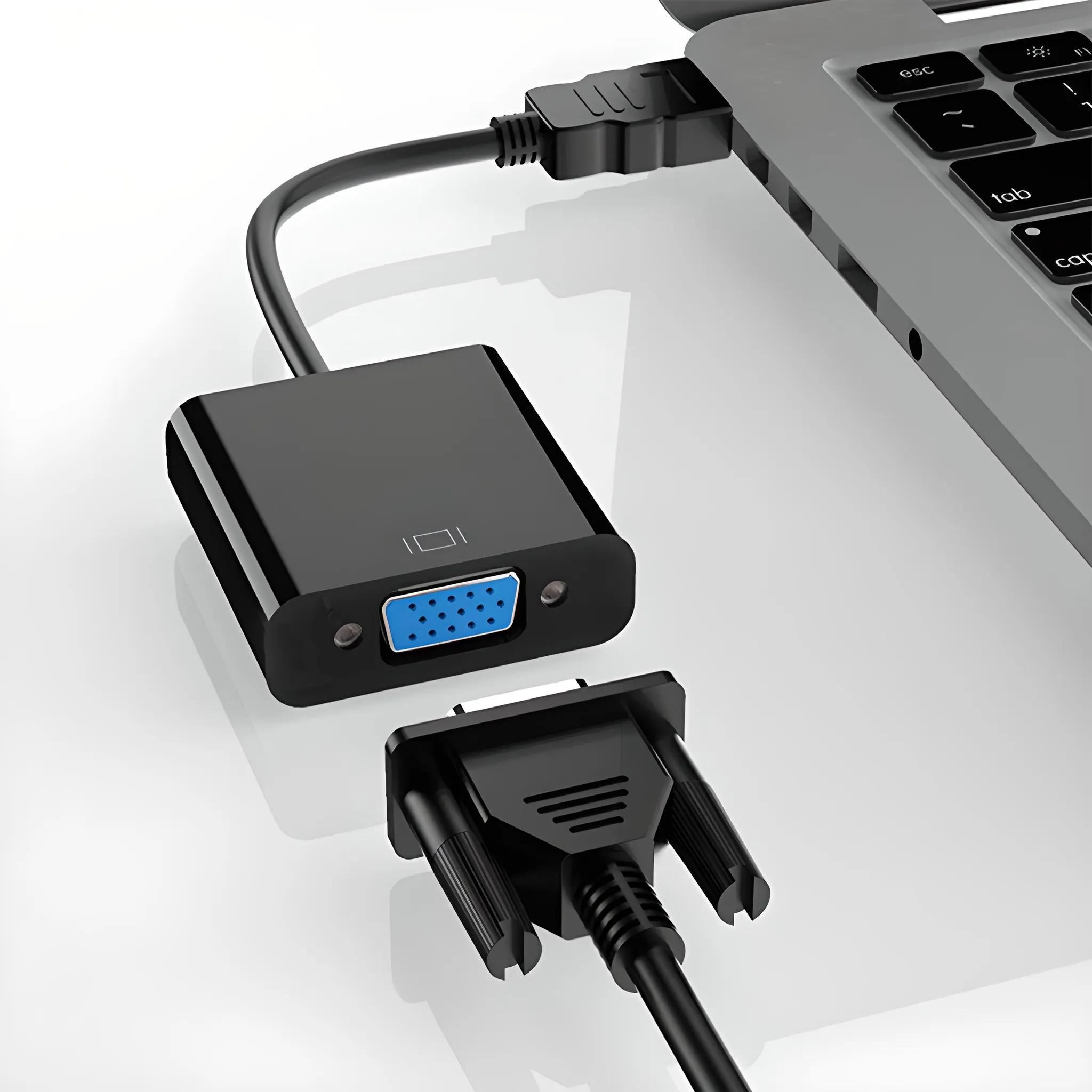 Schwarzer VGA-zu-HDMI-Adapter, der an einen Laptop angeschlossen ist, mit separatem VGA-Anschluss.