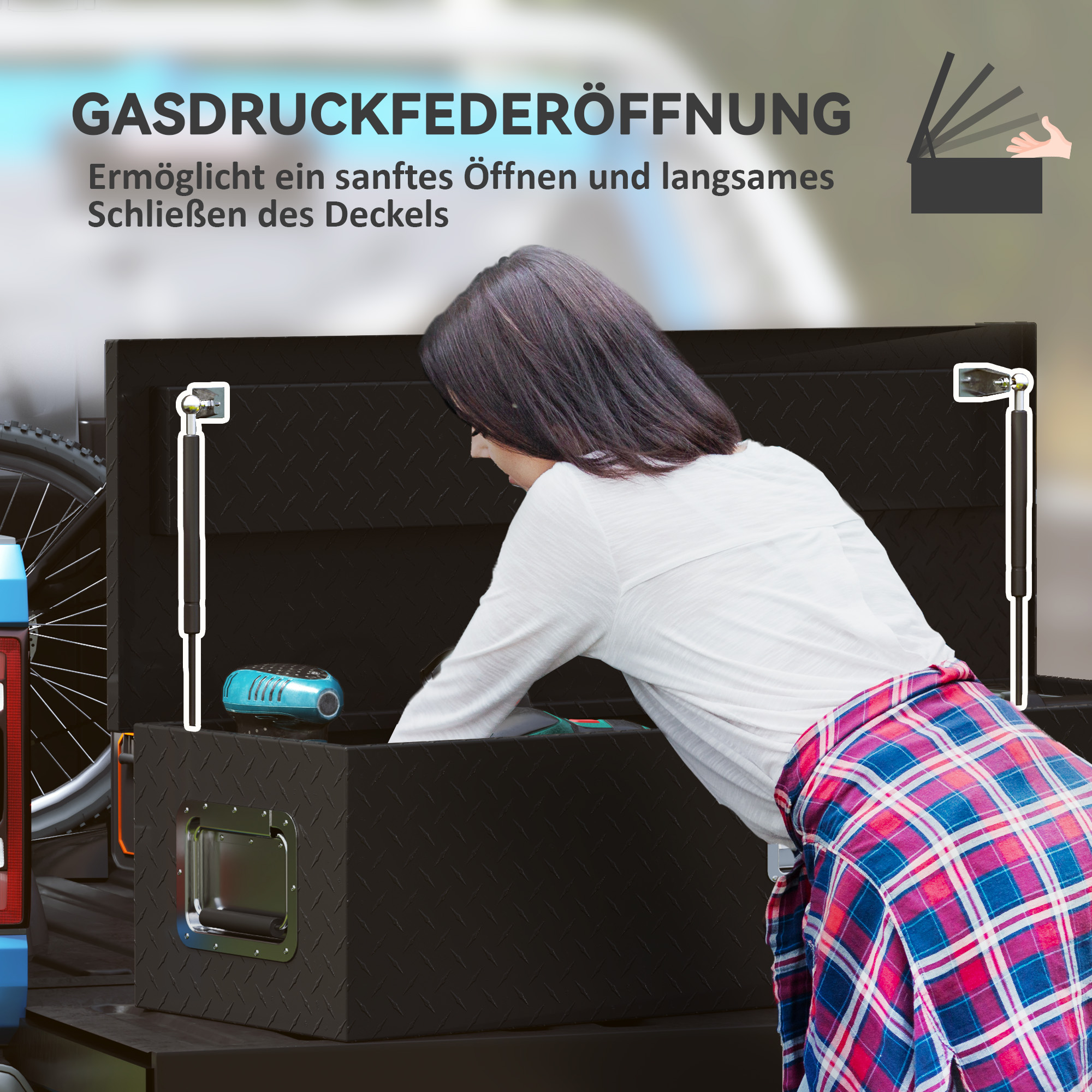 Eine Frau greift in eine schwarze Werkzeugkiste im Heck eines Fahrzeugs, mit Text über die Gasdrucköffnung.