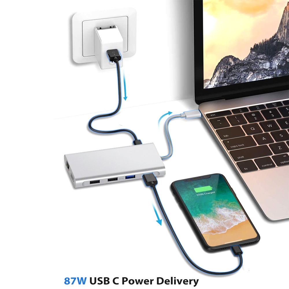 Ein Laptop, ein Smartphone und ein silberner USB-C-Hub, der an eine Steckdose angeschlossen ist. Text: 87W USB C Power Delivery.