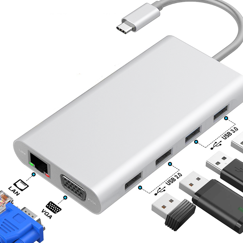 Silberner Hub mit mehreren Anschlüssen, USB, LAN und VGA. Angeschlossenes USB-C-Kabel. Einige USB-Geräte sind eingesteckt.