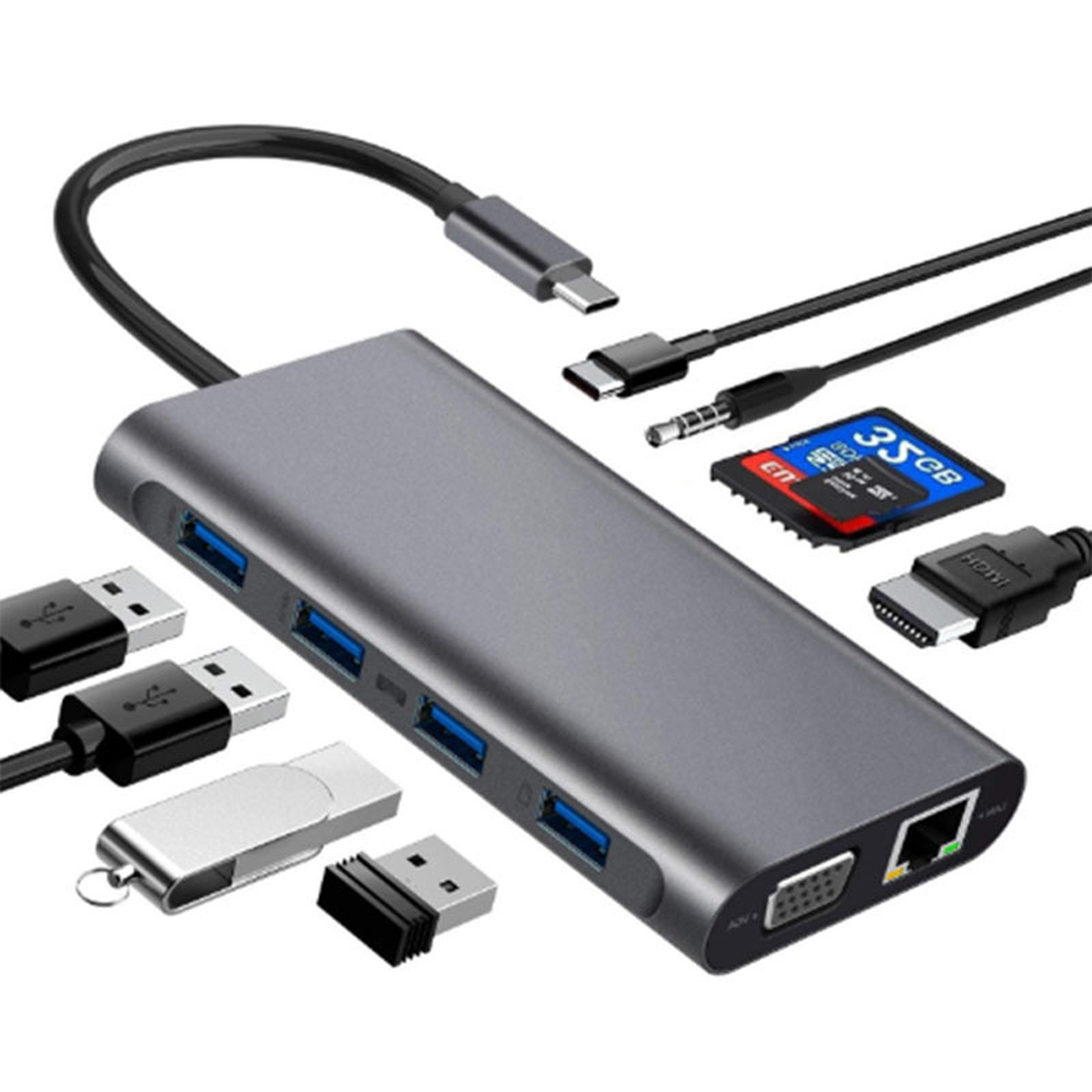 Ein grauer USB-Hub mit verschiedenen angeschlossenen Geräten, darunter USB-Laufwerke, SD-Karte, HDMI- und VGA-Anschlüsse.