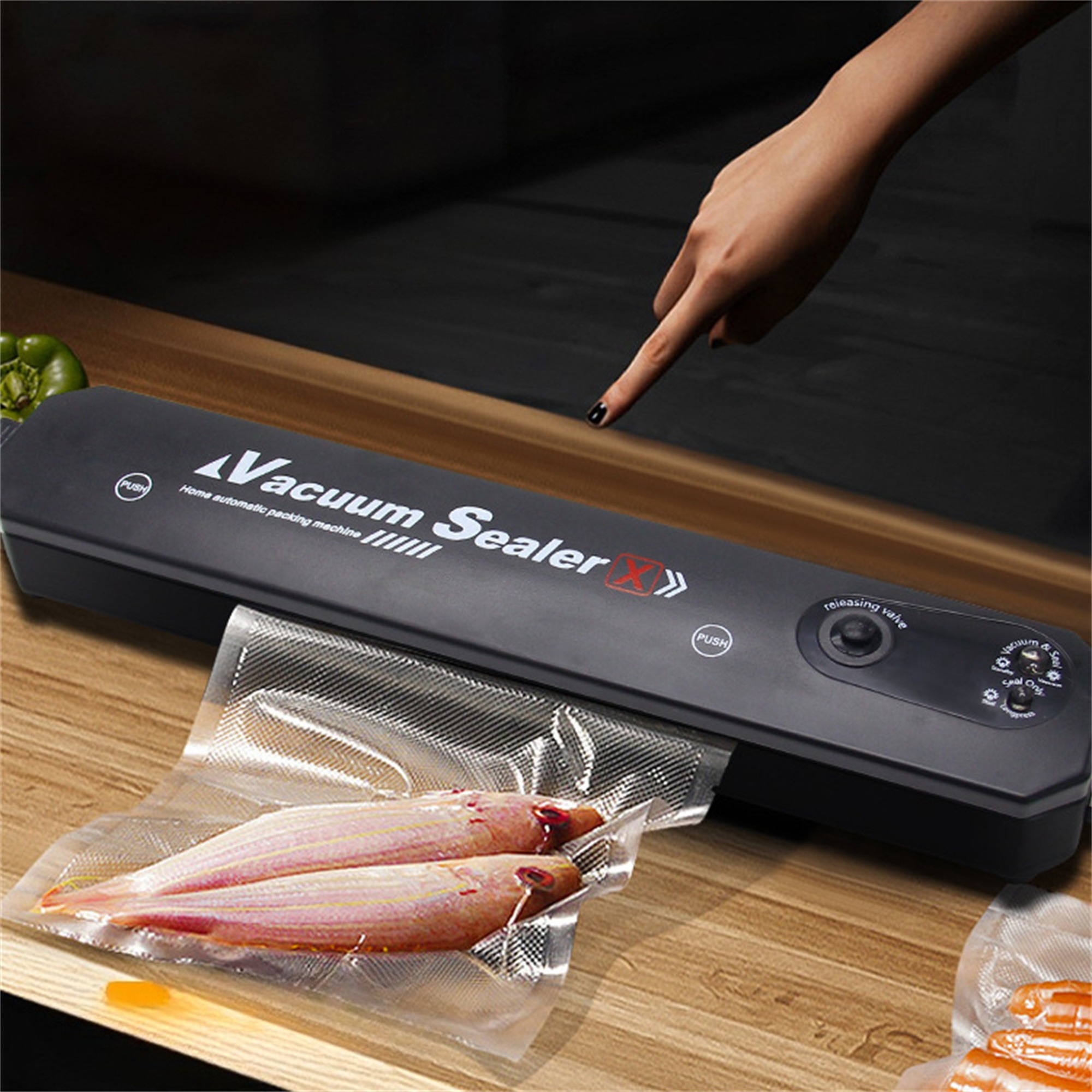 Vakuumiergerät, das Fisch versiegelt. Schwarze Maschine auf Holz, versiegelter Fisch im Beutel.