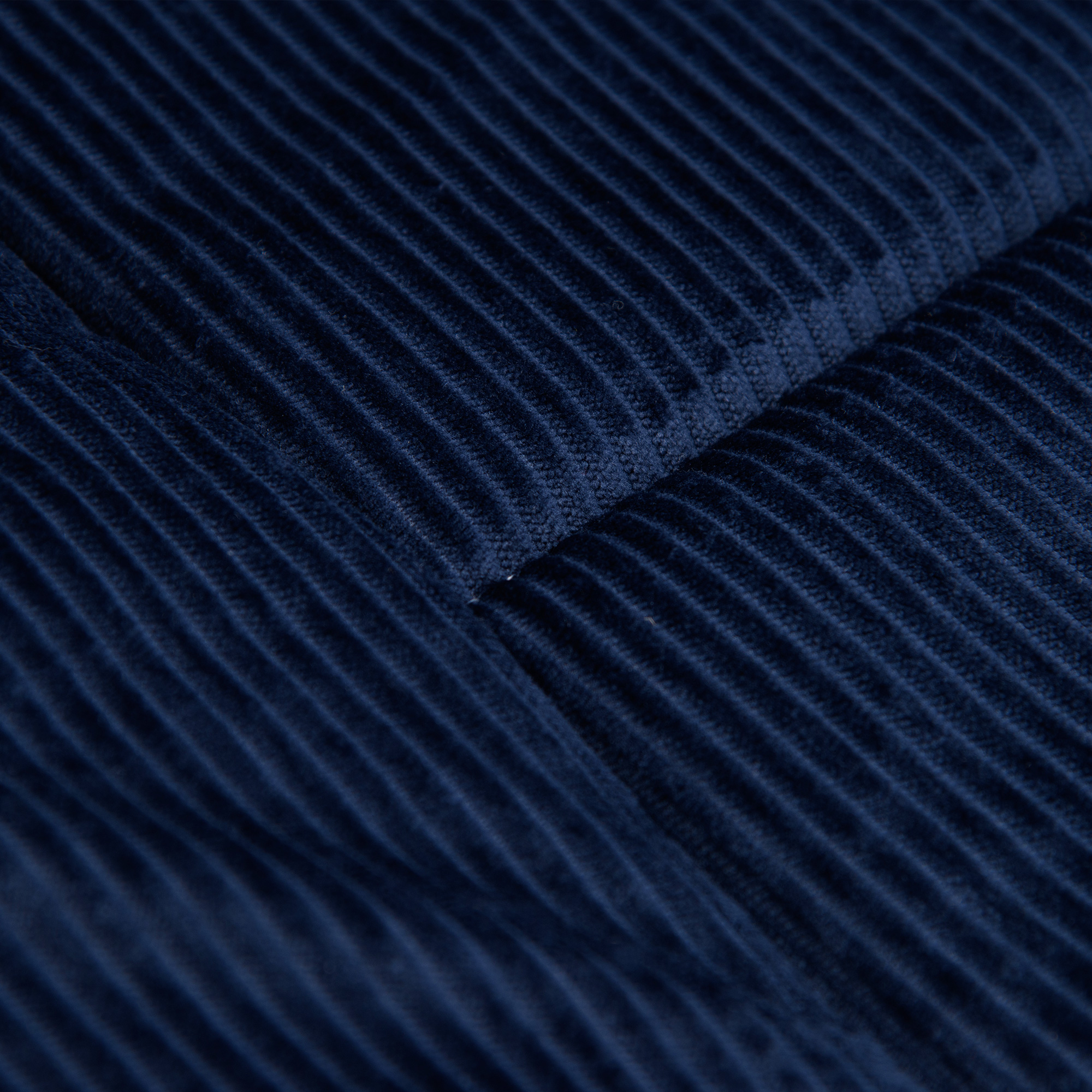 Nahaufnahme des marinefarbenen Cordstoffs. Zeigt die detaillierte Textur des Materials.