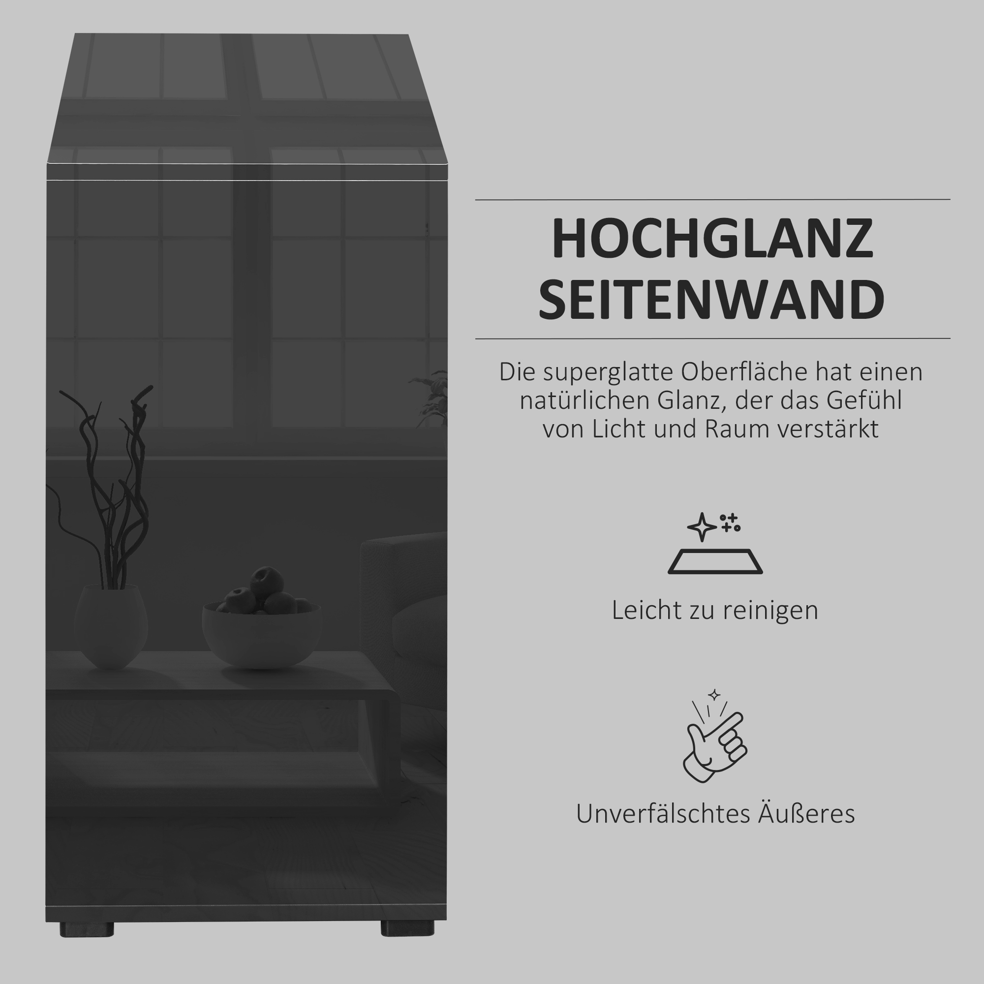 Ein schwarzer Hochglanzschrank mit Text, der seine Oberfläche beschreibt, im Hintergrund Dekoration.