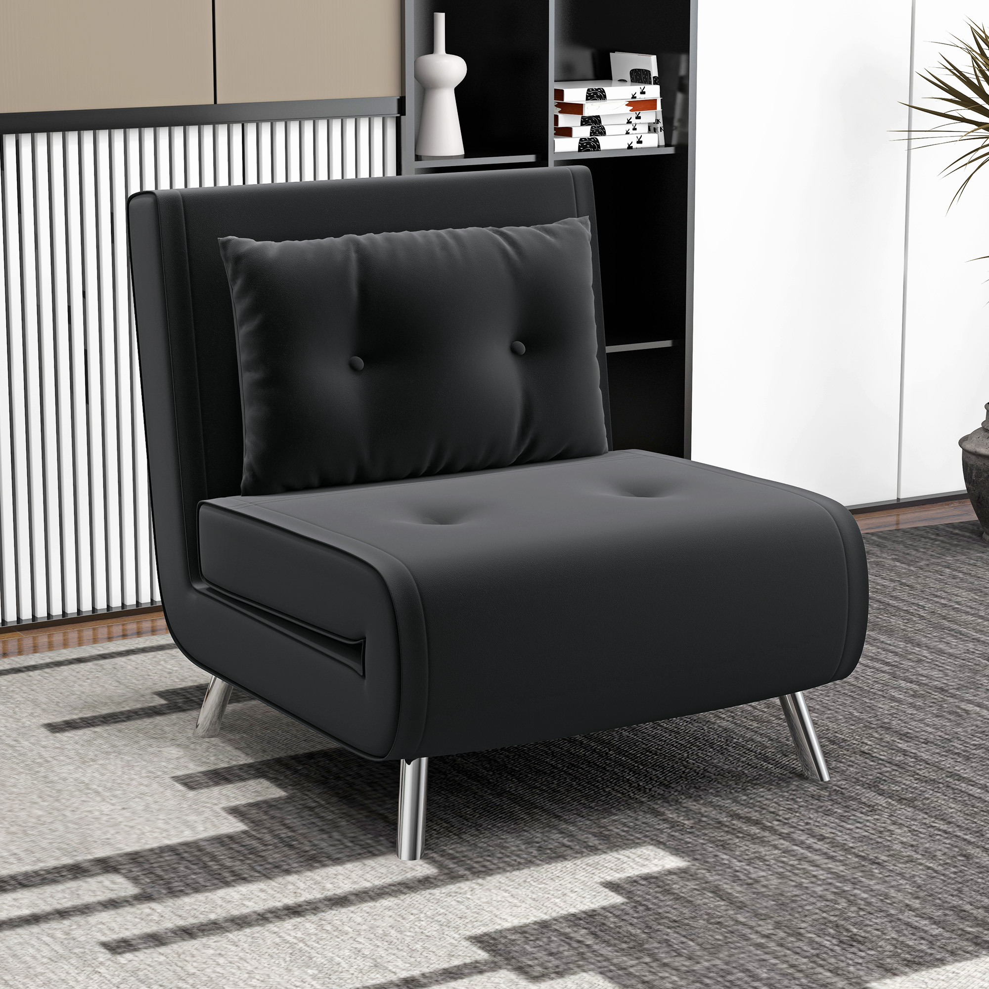 Ein schwarzes Schlafsofa mit schwarzem Kissen, vor einer Wand mit Bücherregal und Dekoration.