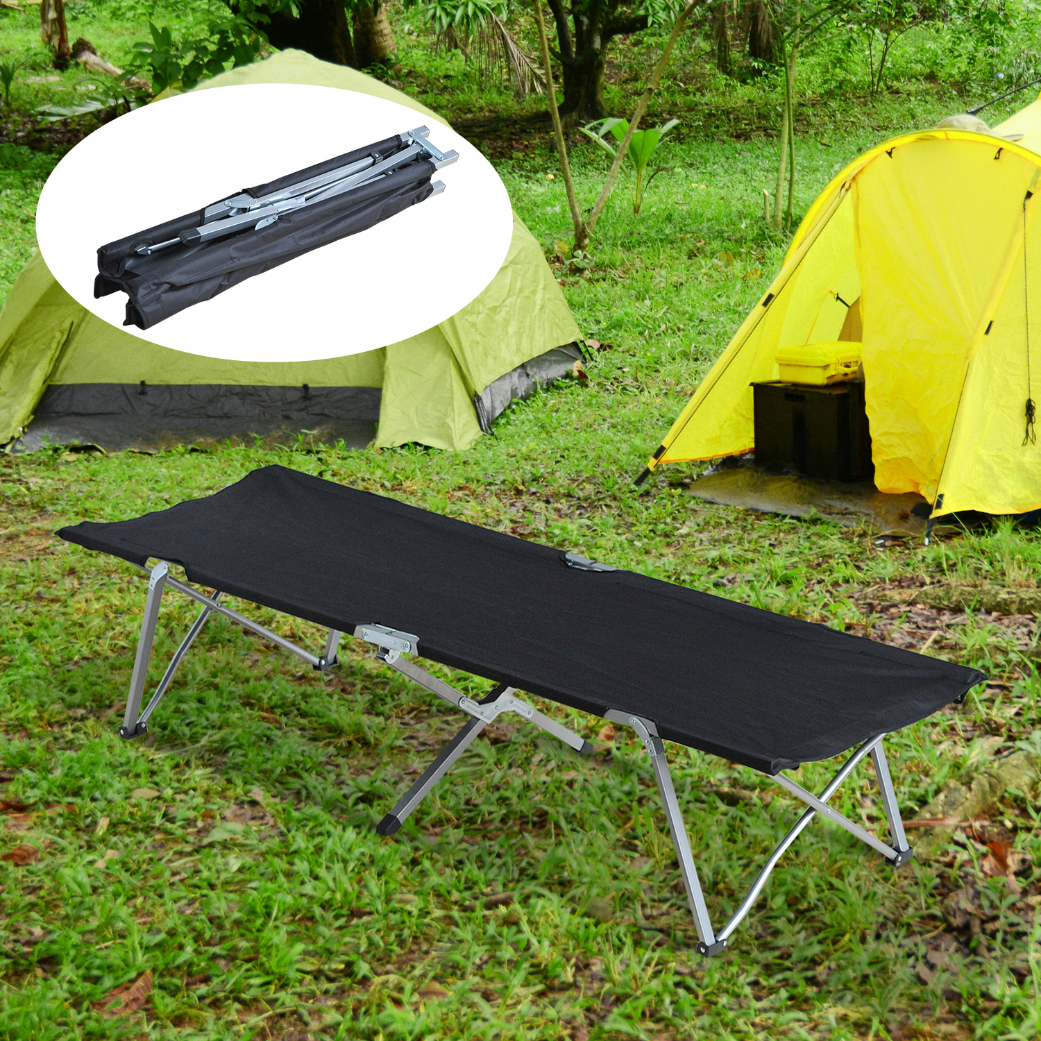 Eine schwarze Campingliege, die in einem grasbewachsenen Bereich aufgestellt wurde, mit Zelten im Hintergrund.