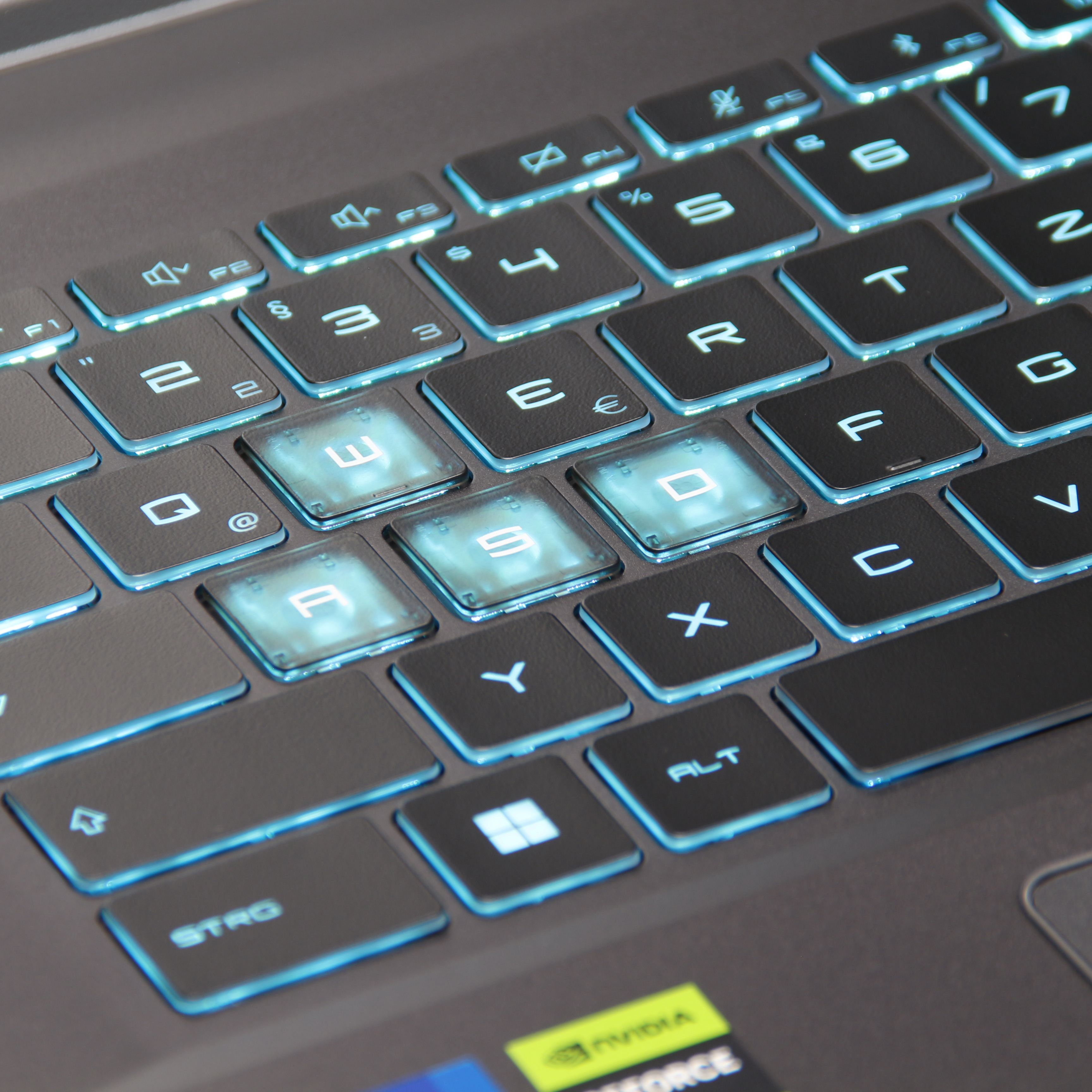 Nahaufnahme einer Laptop-Tastatur mit hintergrundbeleuchteten Tasten. Buchstaben und Zahlen sind sichtbar.