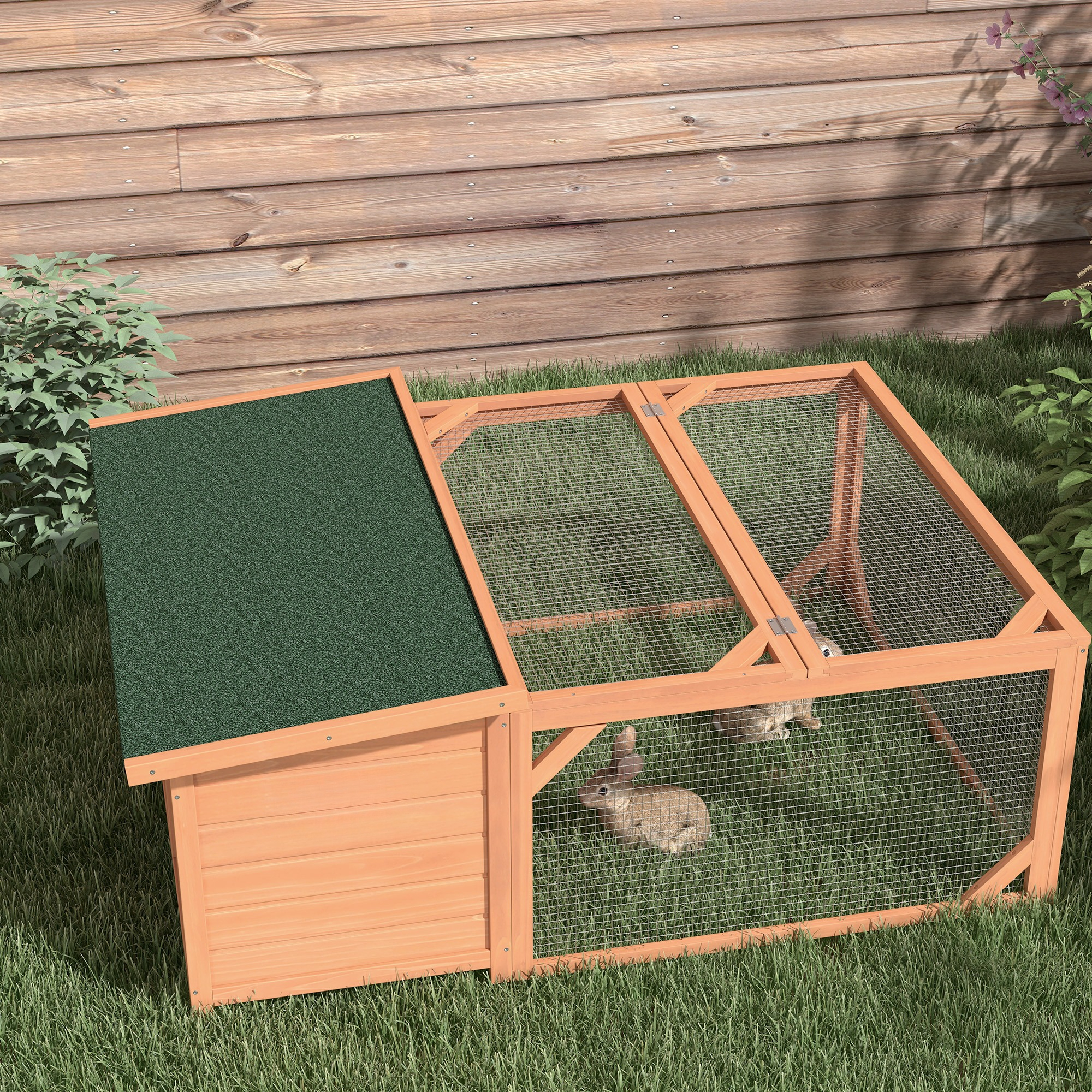 Kaninchenstall aus Holz mit grünem Dach, Gitterseiten und zwei Kaninchen auf Gras.