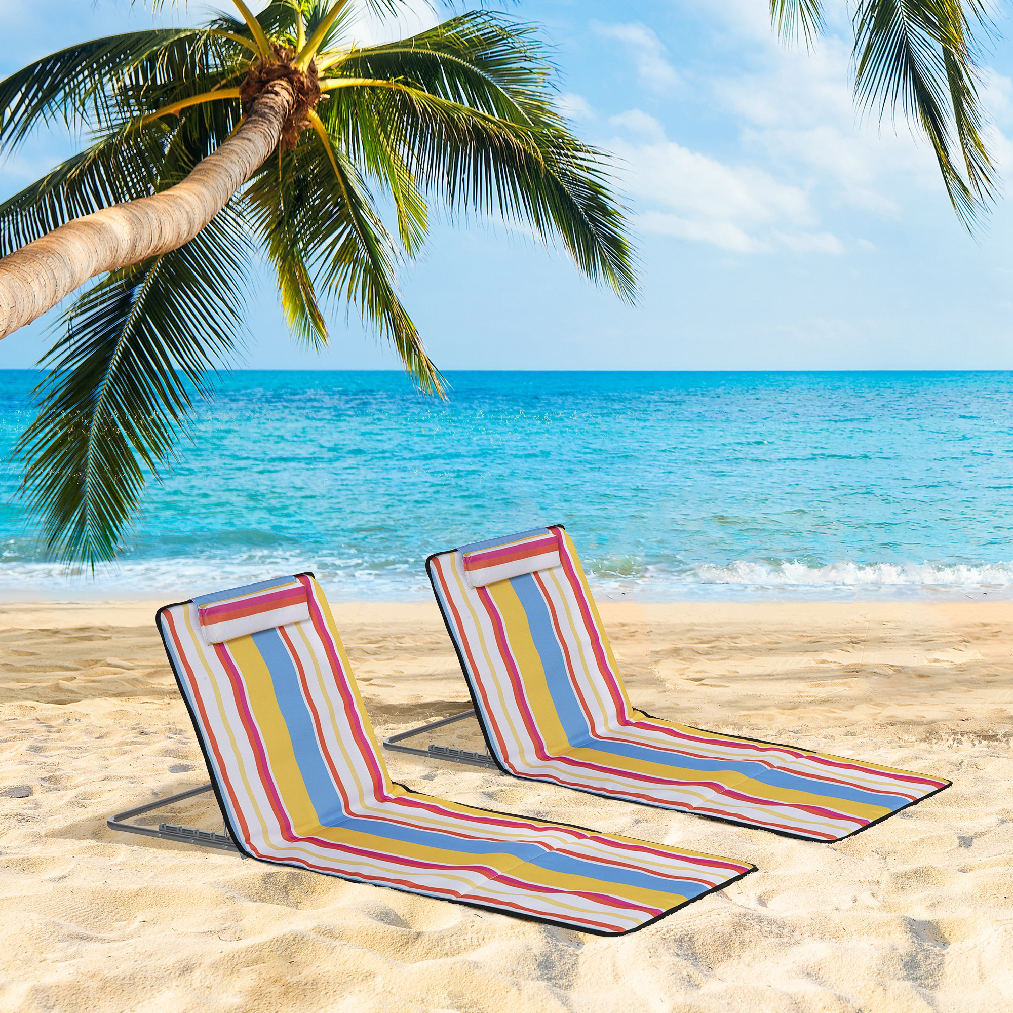 Zwei gestreifte Strandstühle am Sandstrand, unter Palmen, blaues Meer im Hintergrund, sonniger Himmel.