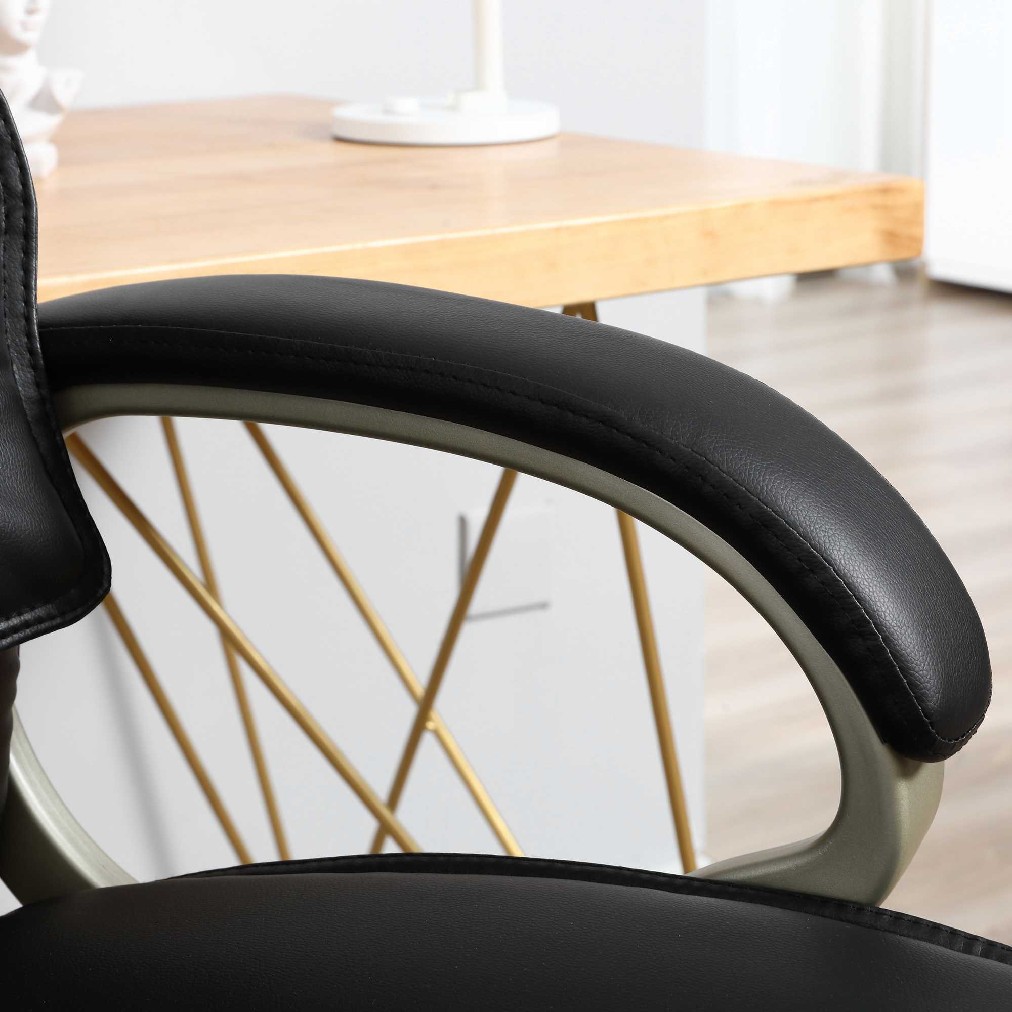 Nahaufnahme einer schwarzen Leder-Bürostuhllehne mit grauem Rahmen und einem Holztisch im Hintergrund.