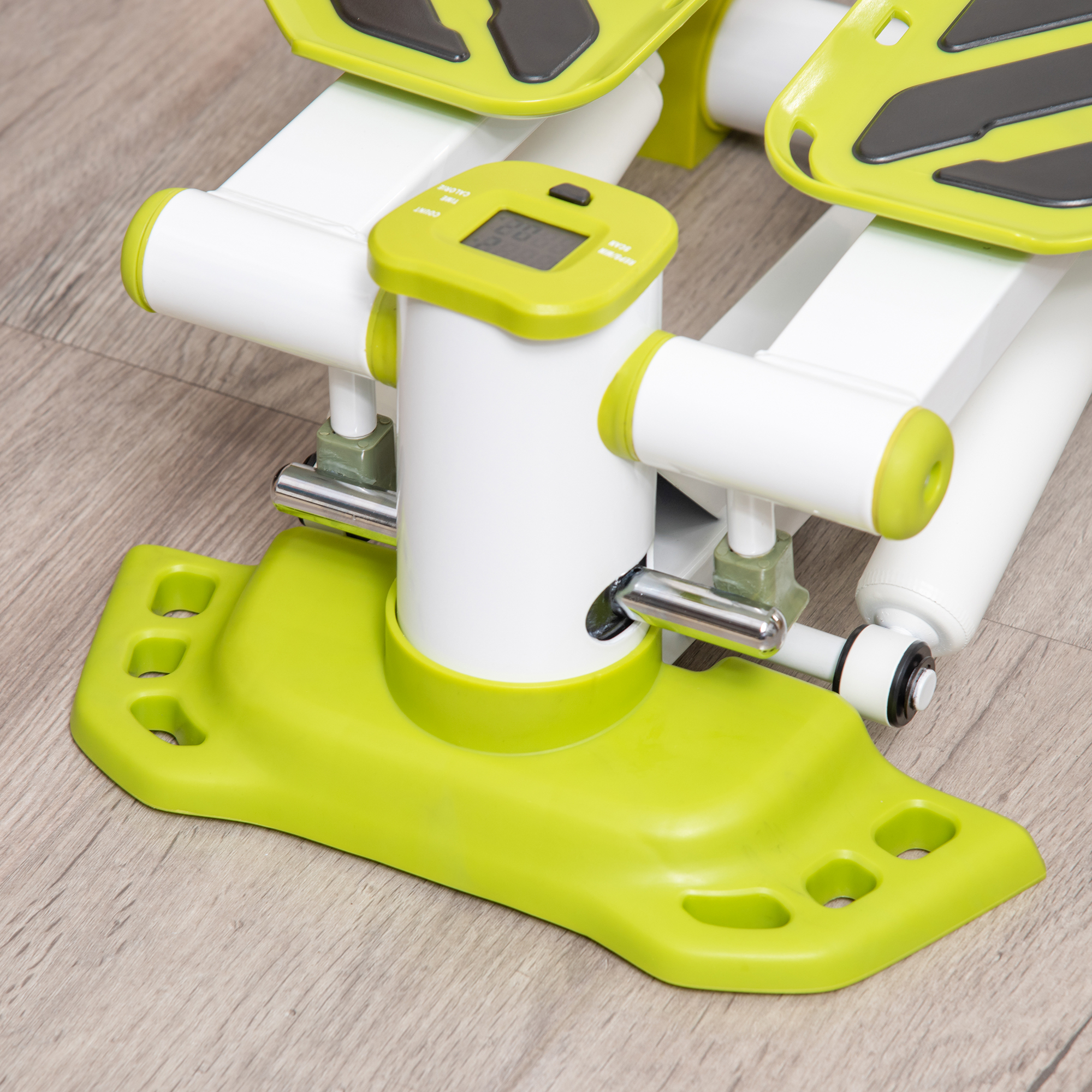 Nahaufnahme einer Stepper-Maschine mit Display, grünem Sockel und Fußpolstern.