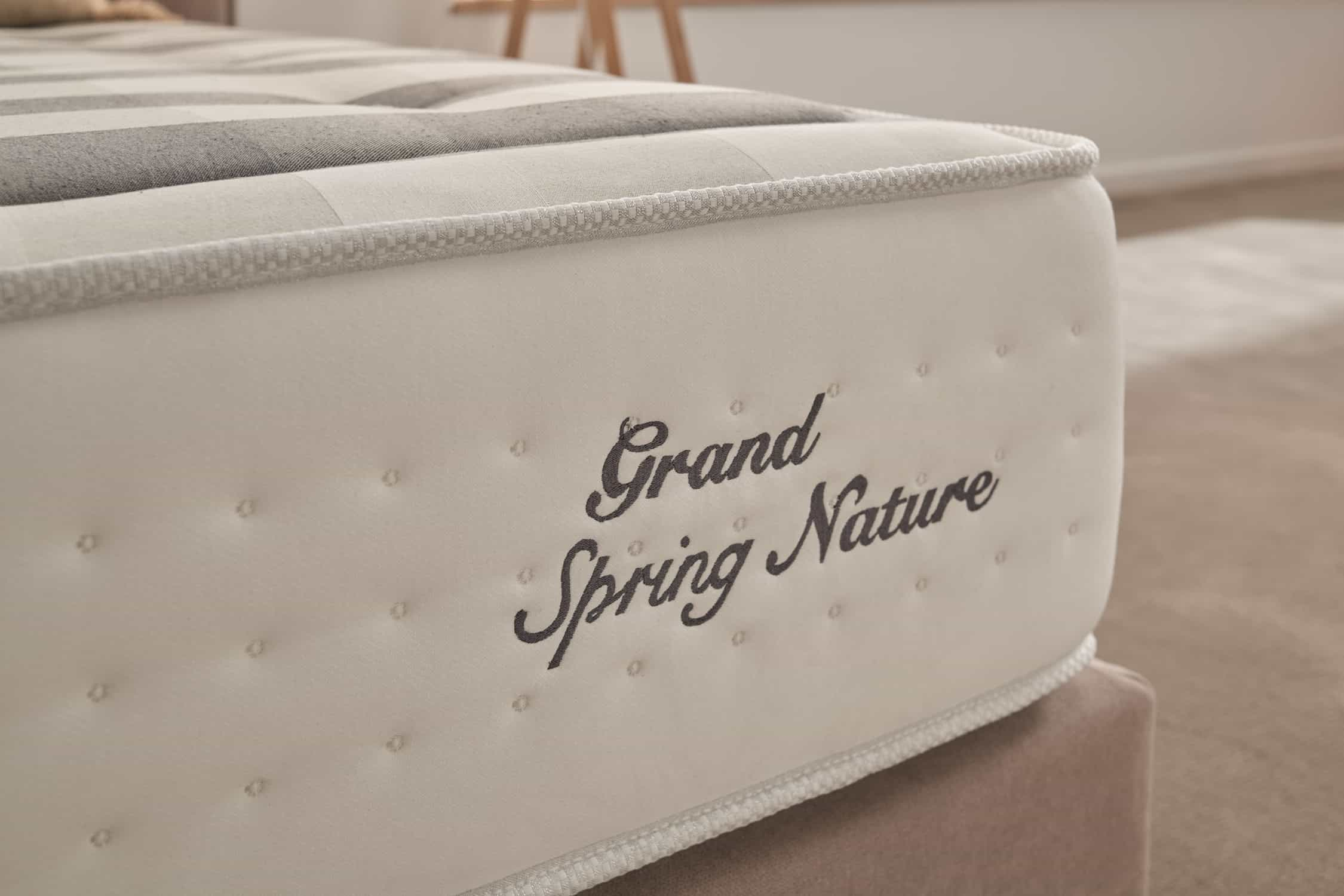 Primer plano de un colchón con las palabras 'Grand Spring Nature' bordadas en el lateral.