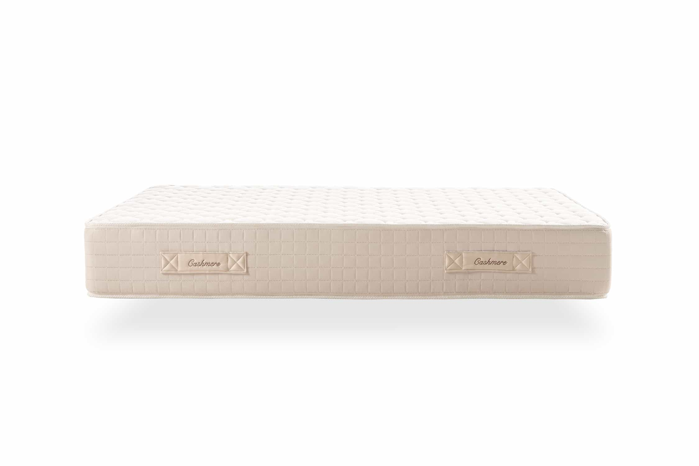 Colchón blanco con borde beige. La etiqueta dice 'Cashmere' en ambos lados.