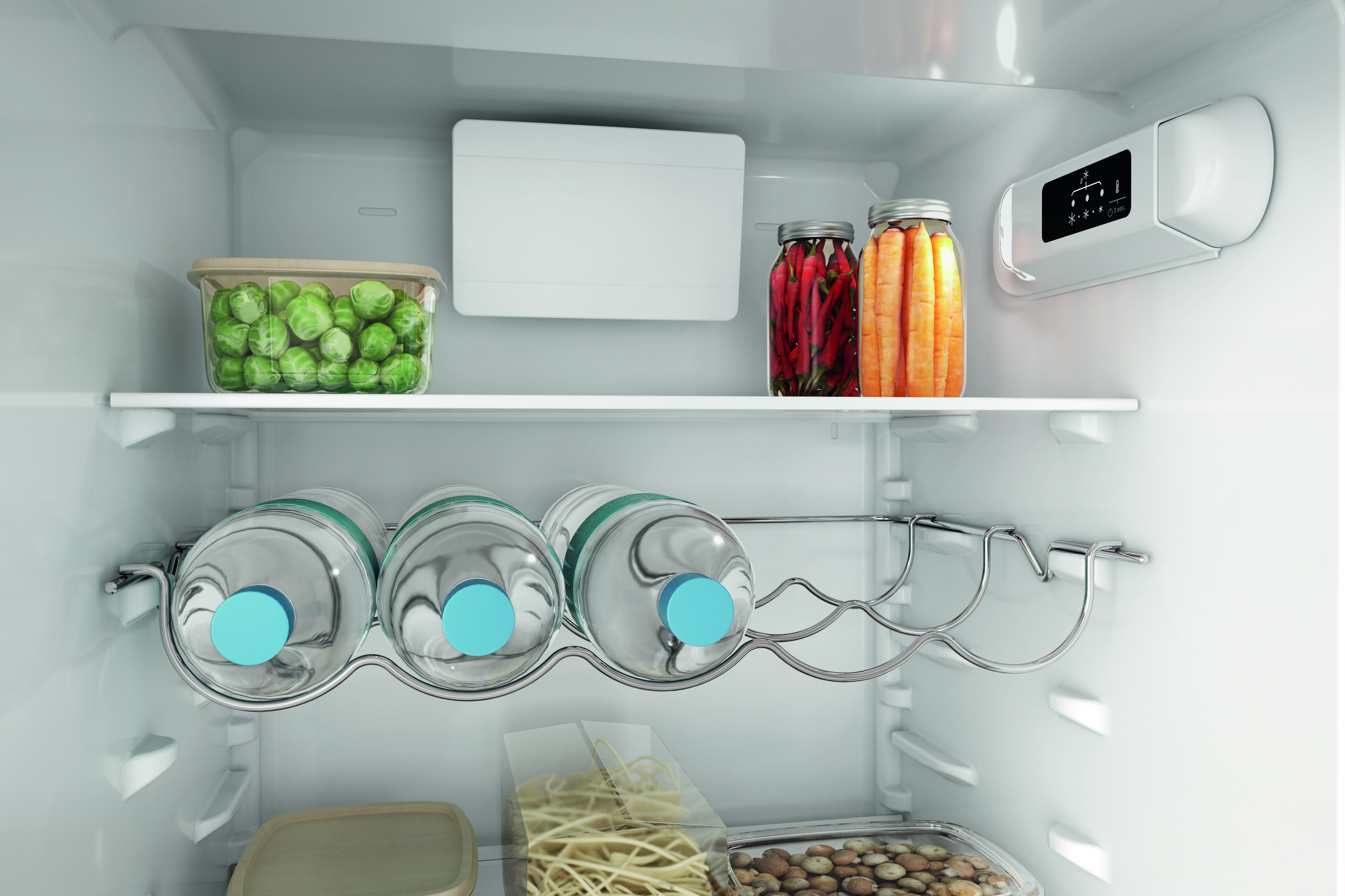 Kühlschrankinnenraum. Gemüse, Wasserflaschen, Gläser und Tabletts auf Regalen. Weißes Interieur, helles Licht.