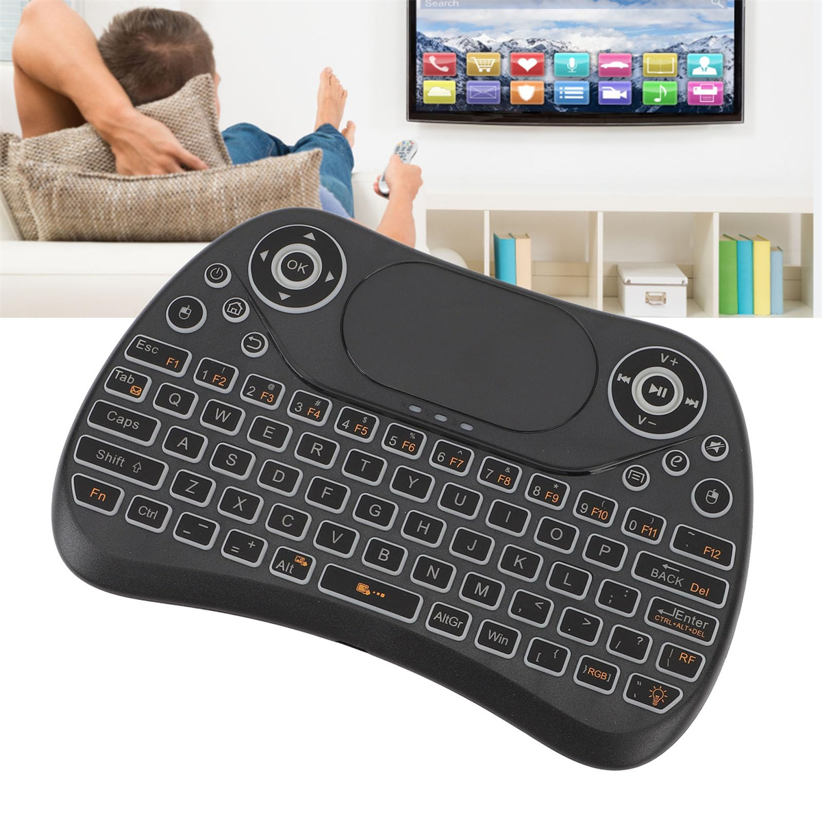 Schwarze Mini-Tastatur mit Tasten und Touchpad. Eine Person liegt zurück, schaut einen Fernseher mit App-Symbolen.