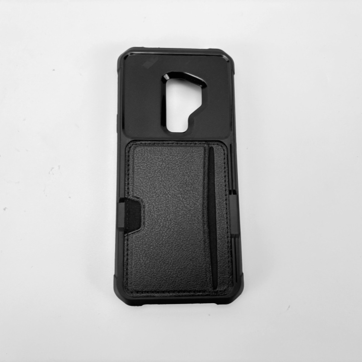Custodia per telefono nera con fessura per carte. Pelle strutturata sul davanti, telaio in plastica dura. Sfondo bianco.