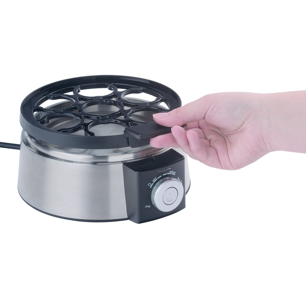 Ręka wyjmuje stojak na jajka. Garnek do jajek jest otwarty, a stojak podnoszony.