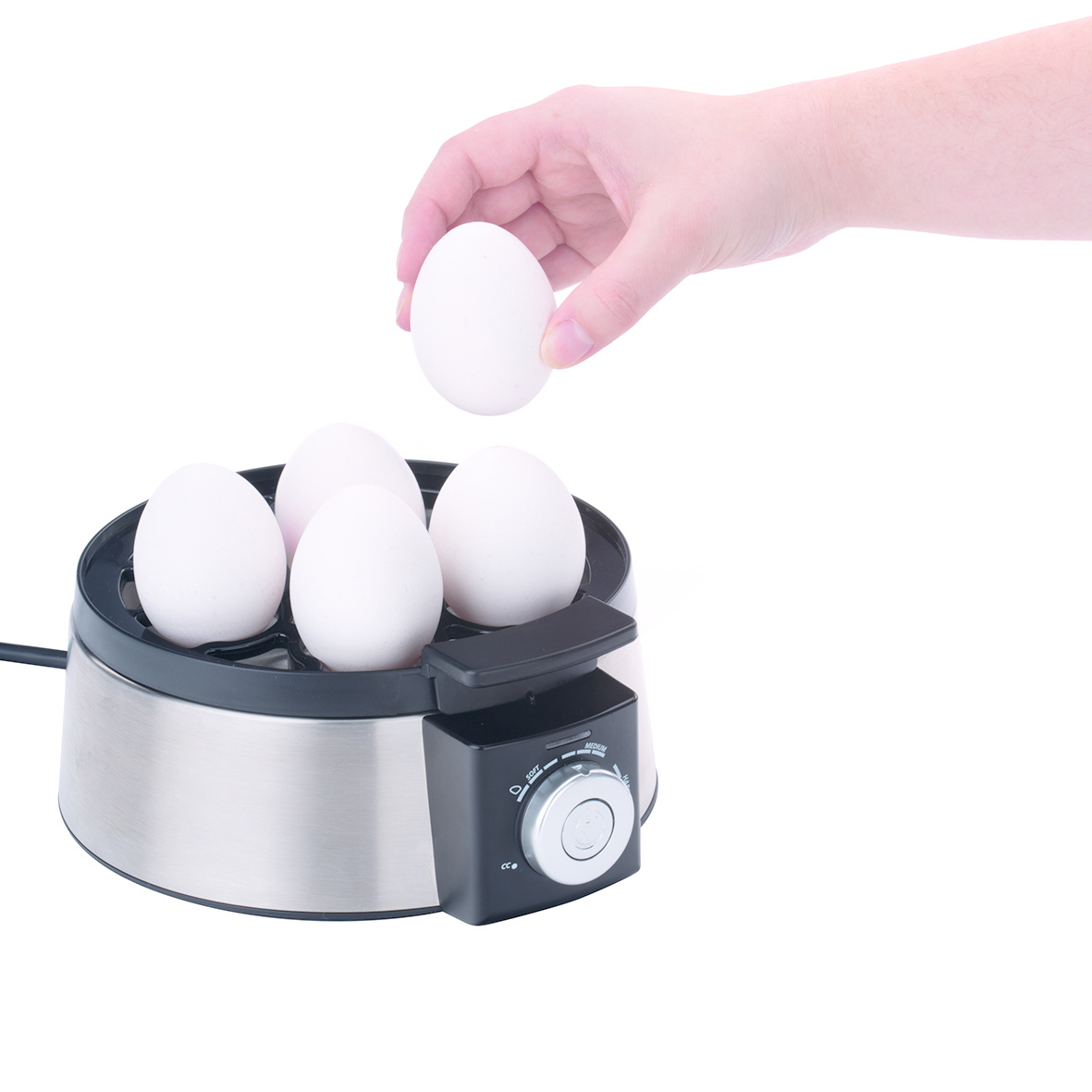 Ręka wkłada białe jajko do urządzenia do gotowania jajek z czterema innymi jajkami. Urządzenie jest na białym tle.