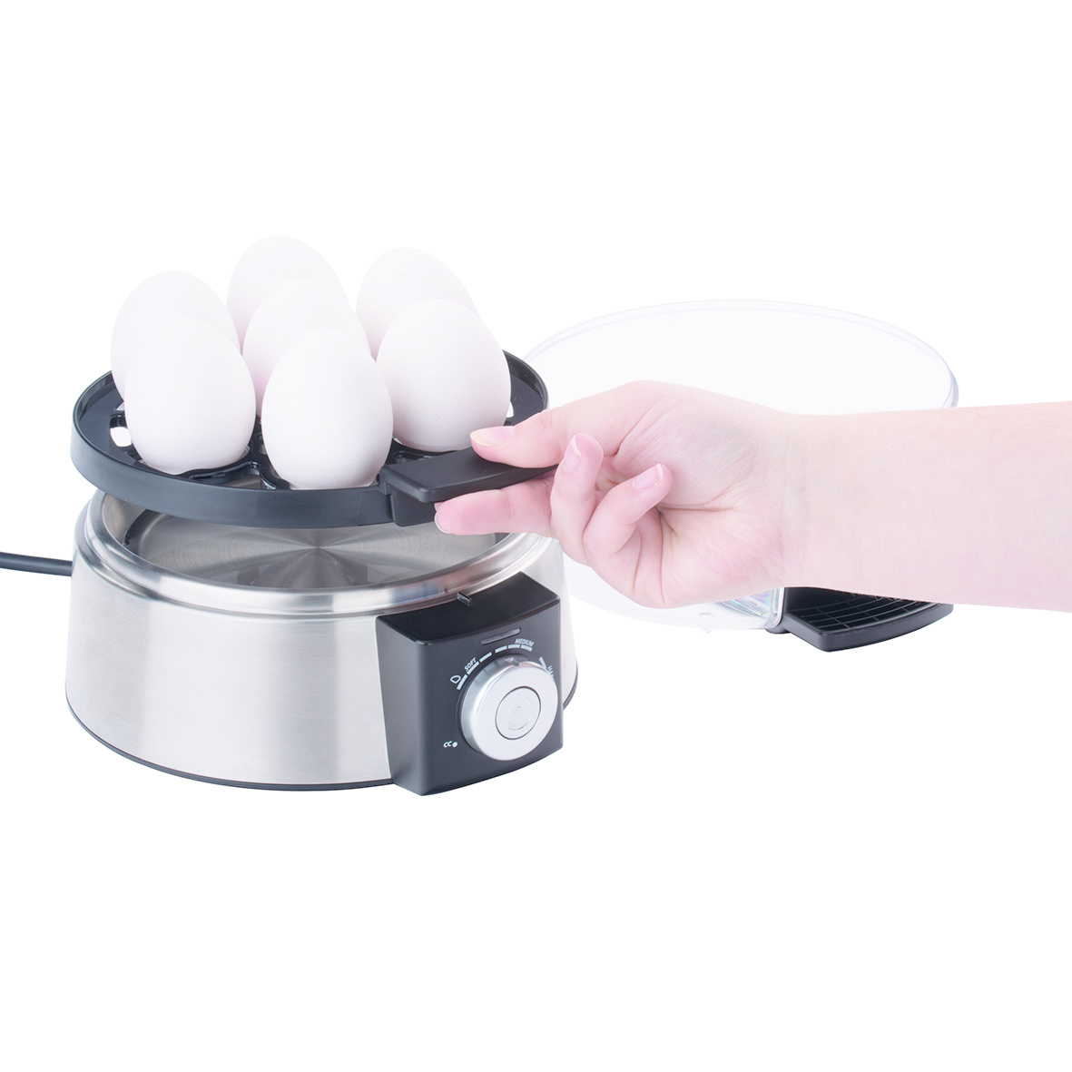 Urządzenie do gotowania jajek z jajkami i ręką wkładającą jajka do urządzenia. Tło jest białe.