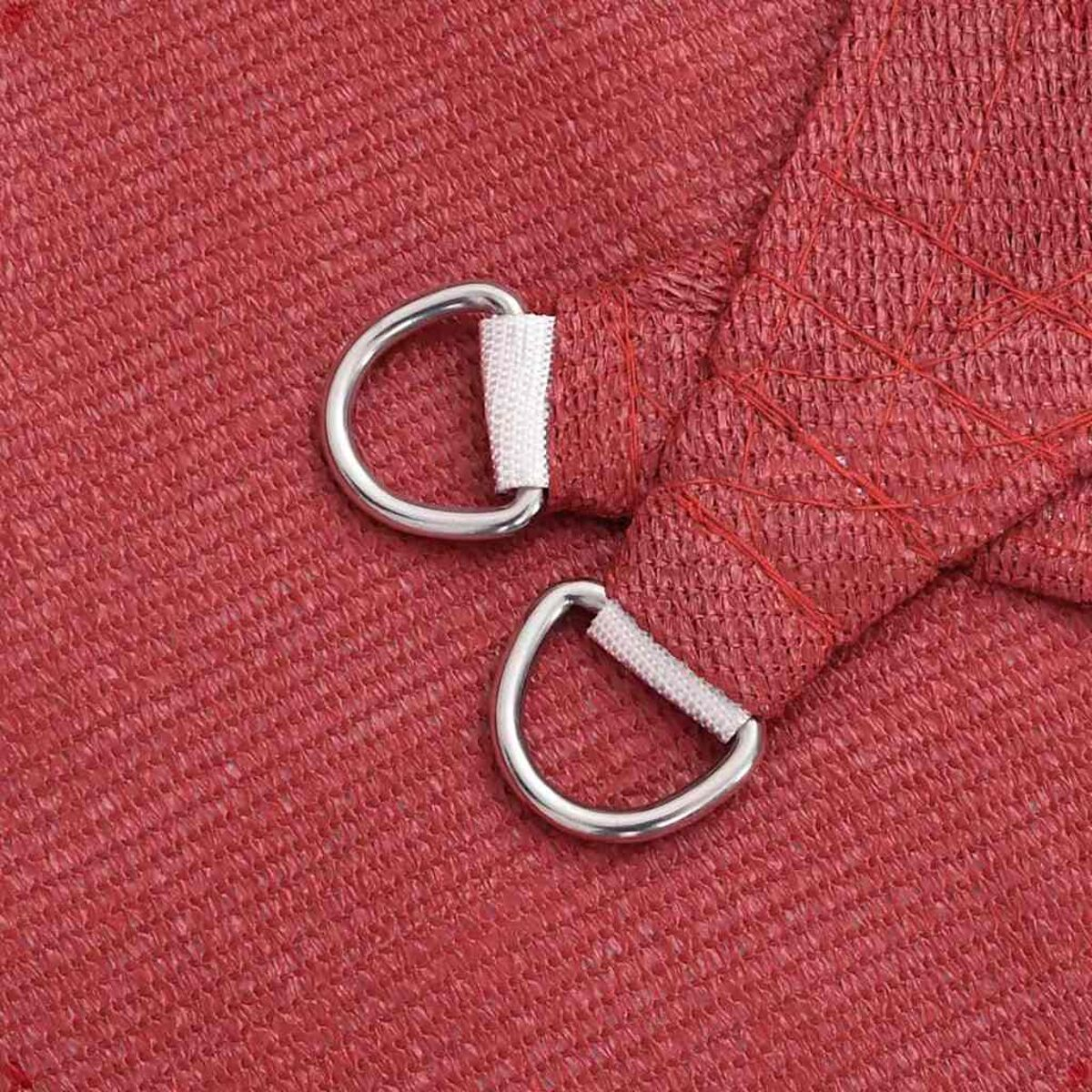 Nahaufnahme des roten Sonnensegels. Zwei silberne D-Ringe, weiße Stoffverstärkung. Roter Hintergrund.
