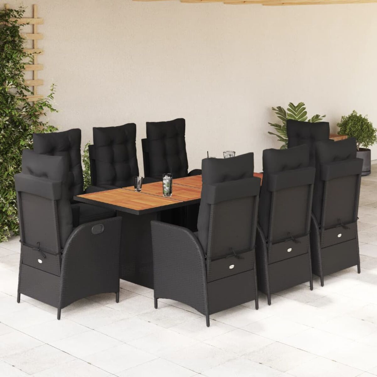 Schwarzes Korbmöbel-Ess-Set mit Tisch und Stühlen. Holzplatte, schwarze Kissen auf Stühlen.