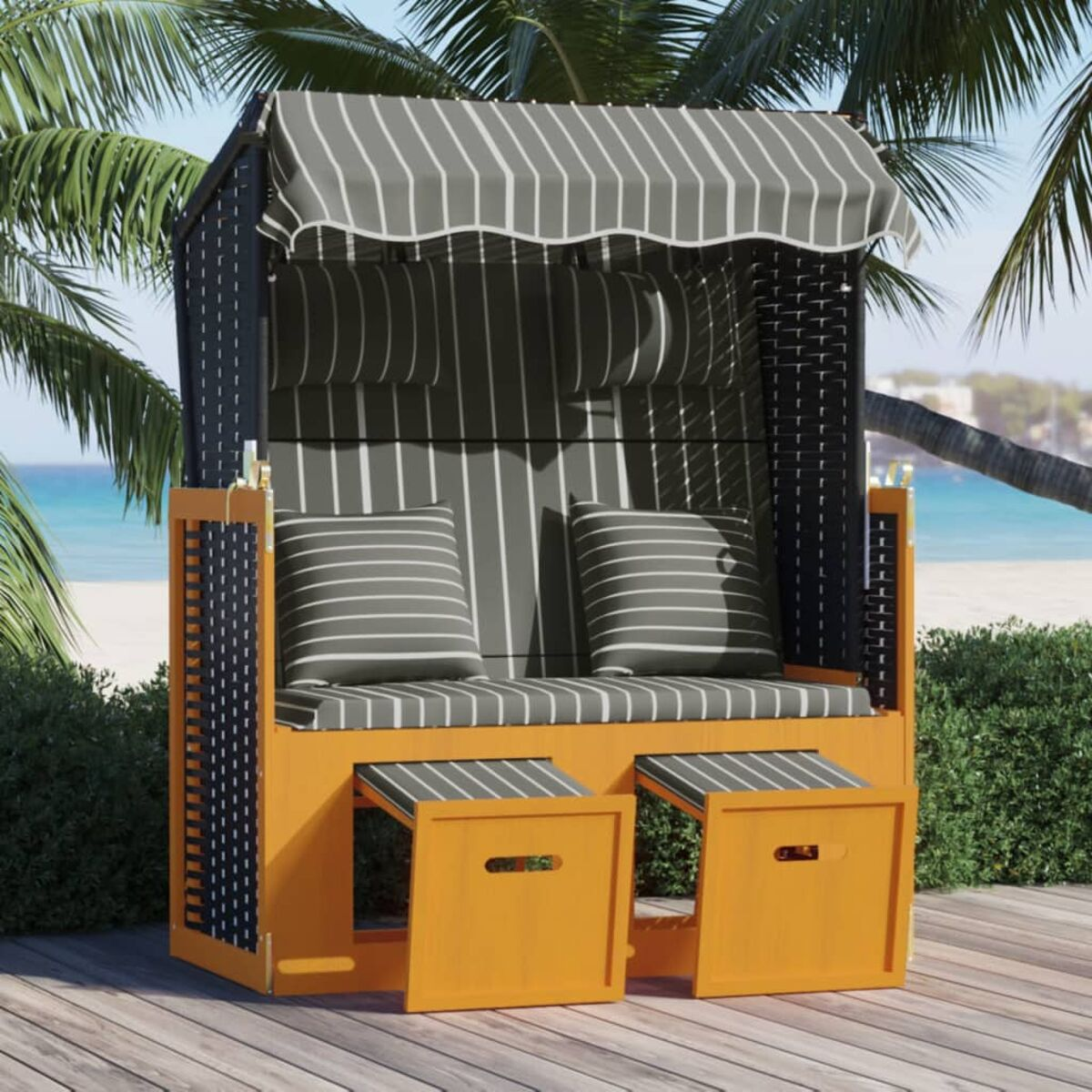Ein Strandkorb mit gestreiftem Verdeck und Kissen.