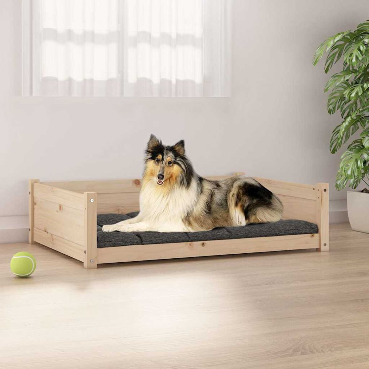Hundebett mit einem Hund, der darauf liegt. Der Hund ist braun, weiß und schwarz.