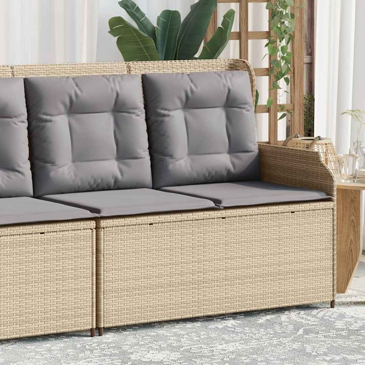 Divano in vimini beige con cuscini grigi.