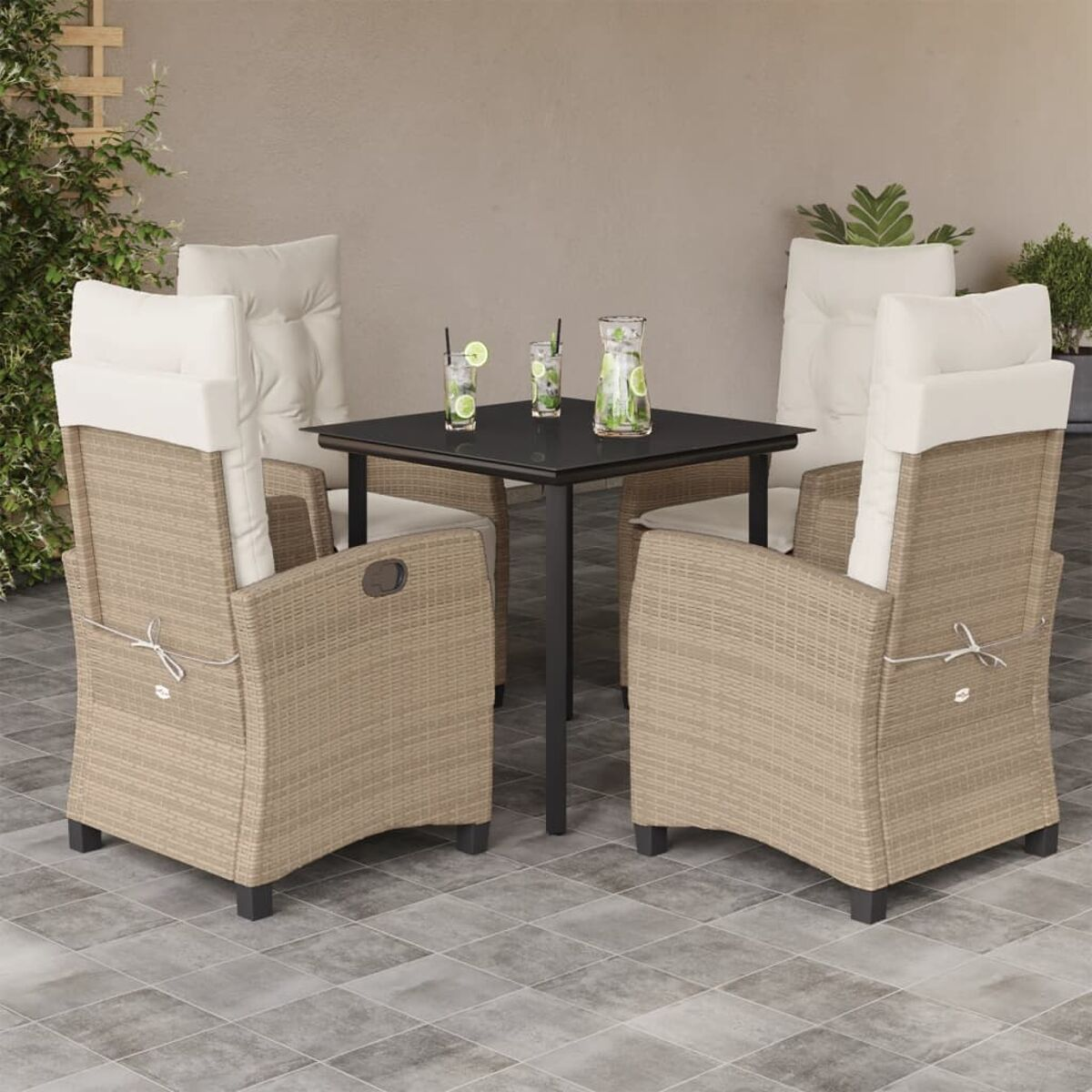 Zwei Rattanstühle, ein Tisch mit Getränken, auf Fliesenboden, mit neutralem Hintergrund.