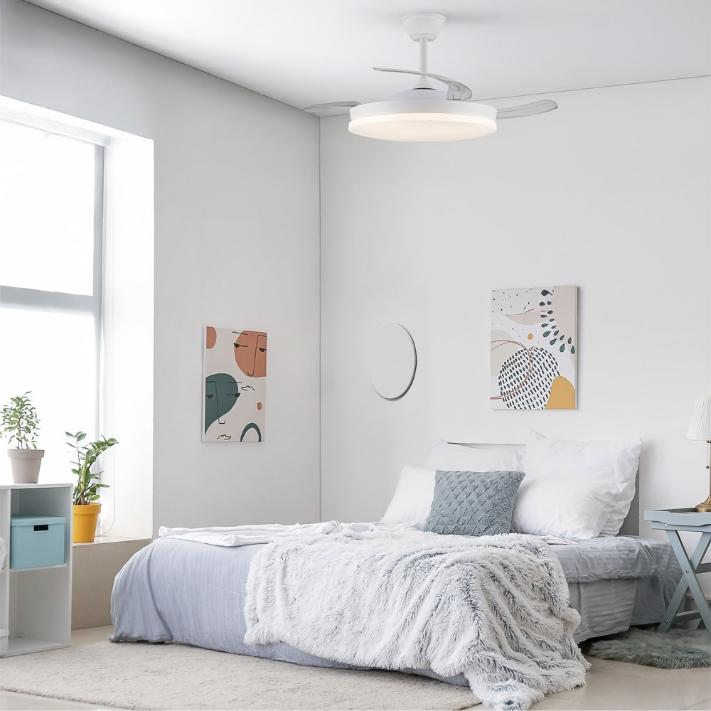 Dormitorio con ventilador de techo blanco y arte. Cama, ventana y mesita con lámpara. Colores neutros.