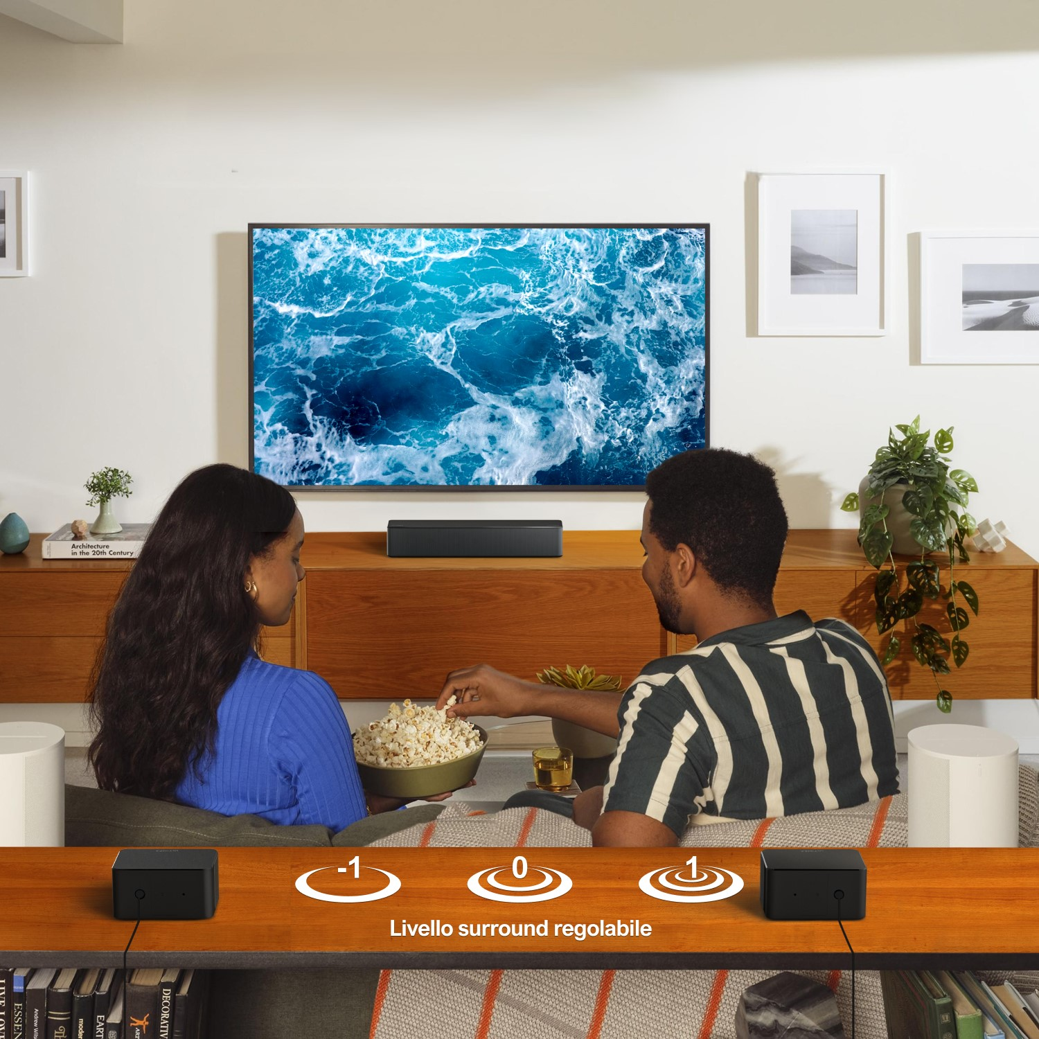 Una coppia mangia popcorn davanti alla TV. Gli altoparlanti sono ai lati. Livello surround regolabile.