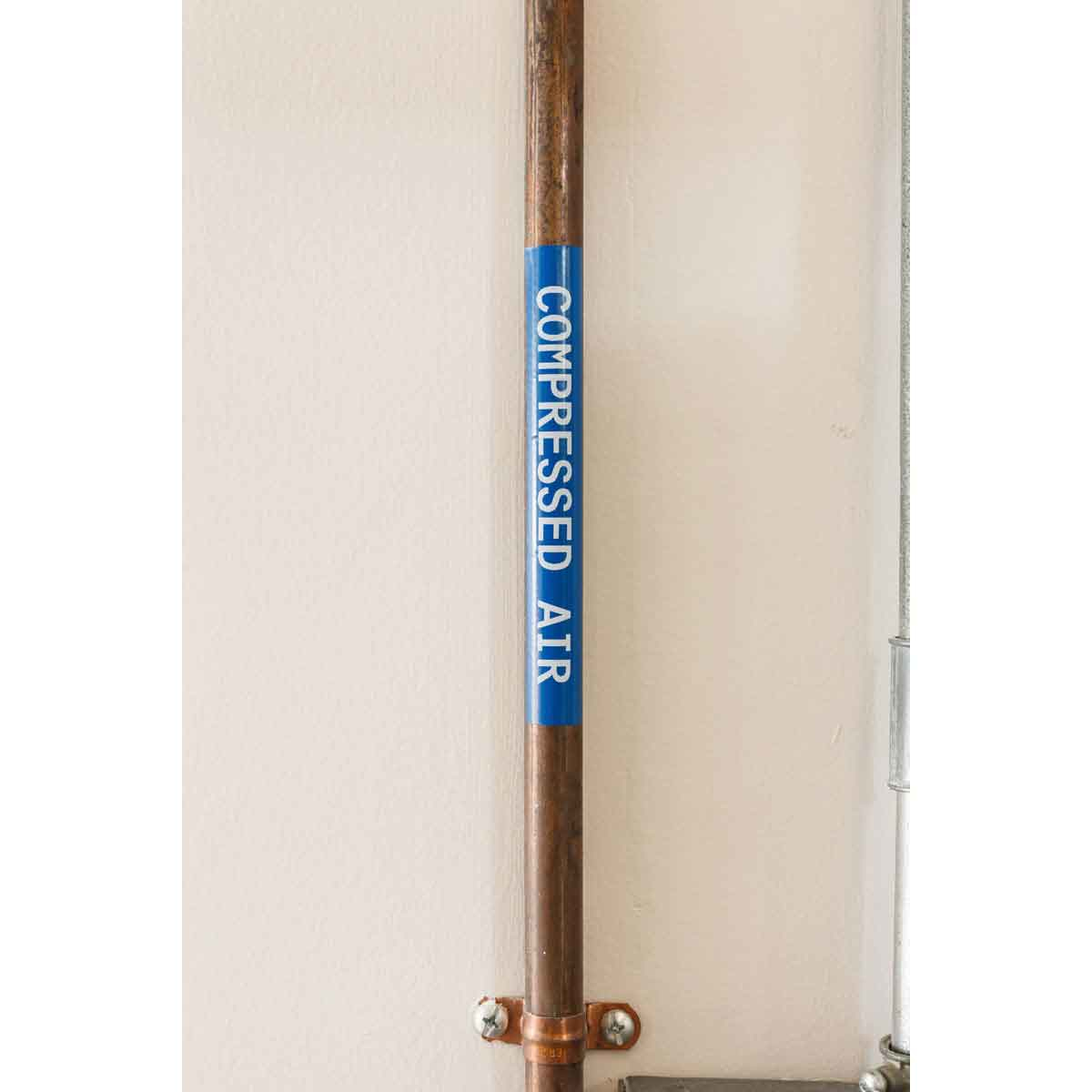 Tubo di rame con un'etichetta che dice 'ARIA COMPRESSA'.