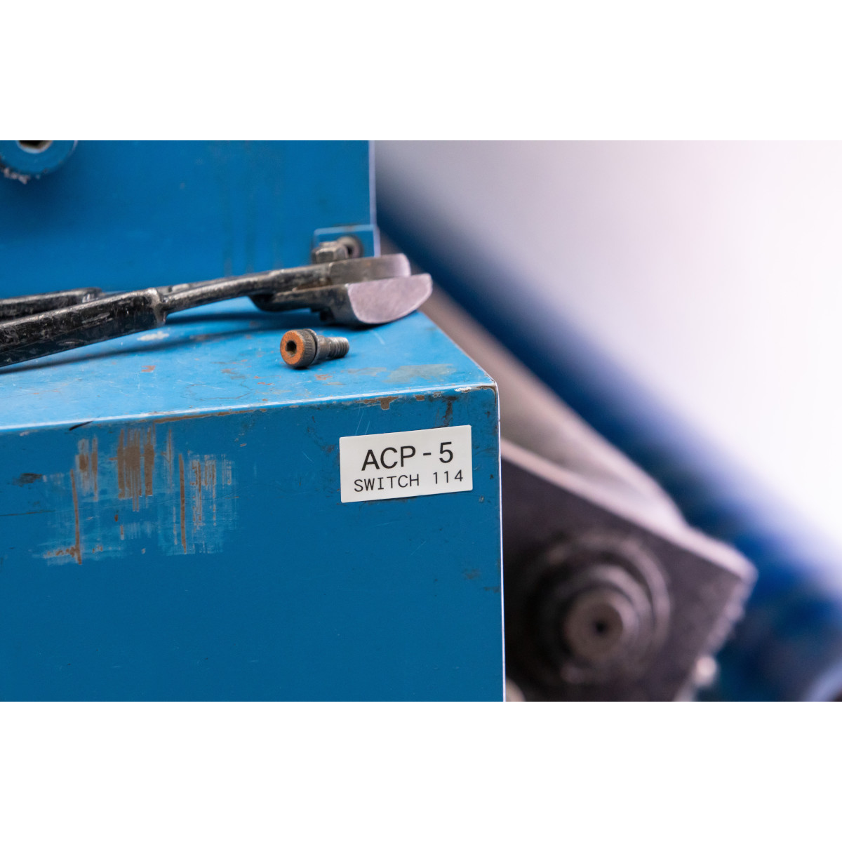 Scatola di metallo blu con attrezzi, etichetta "ACP-5 SWITCH 114".