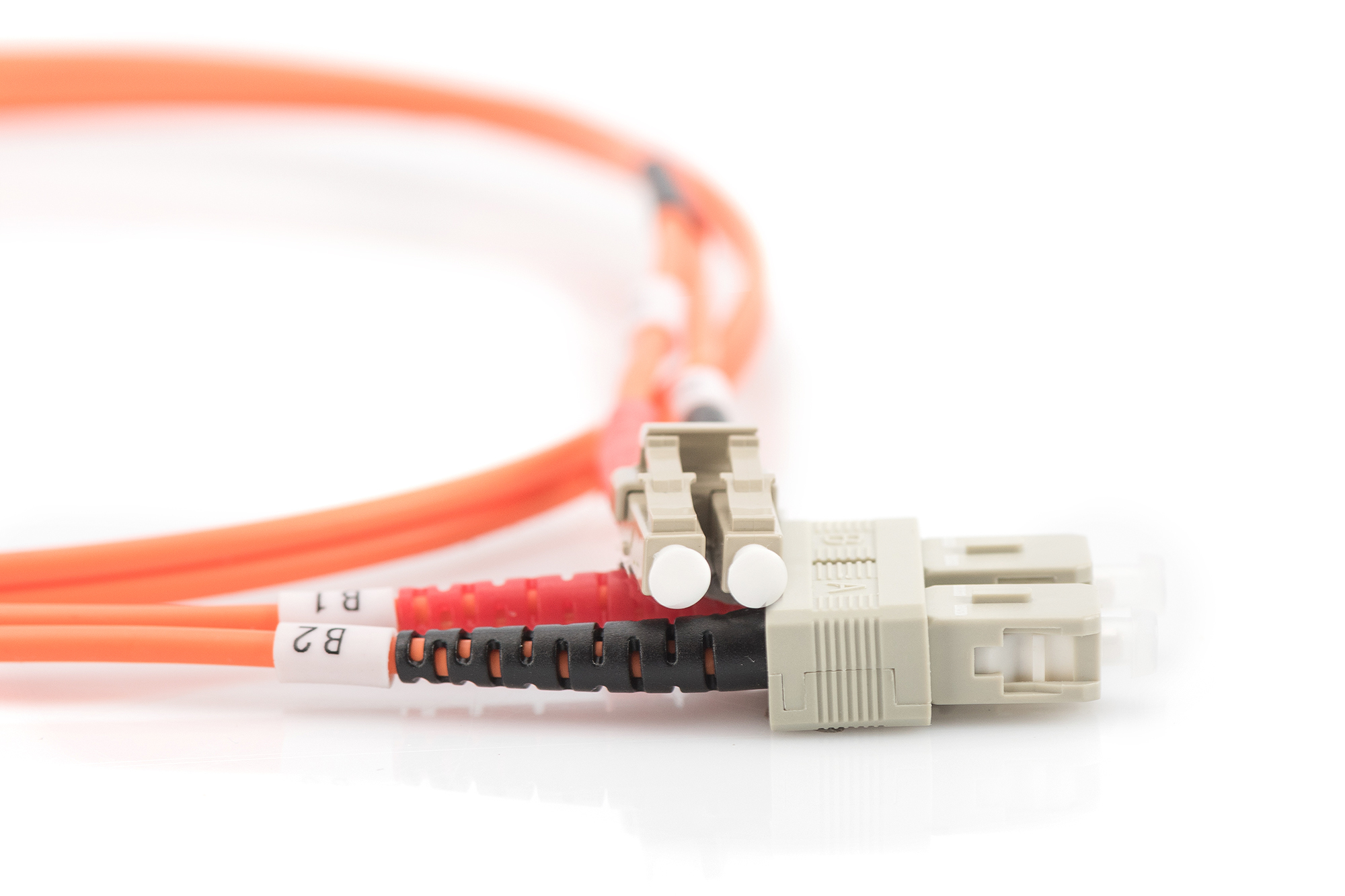Primo piano di cavi in fibra ottica arancioni con connettori, sfondo bianco.