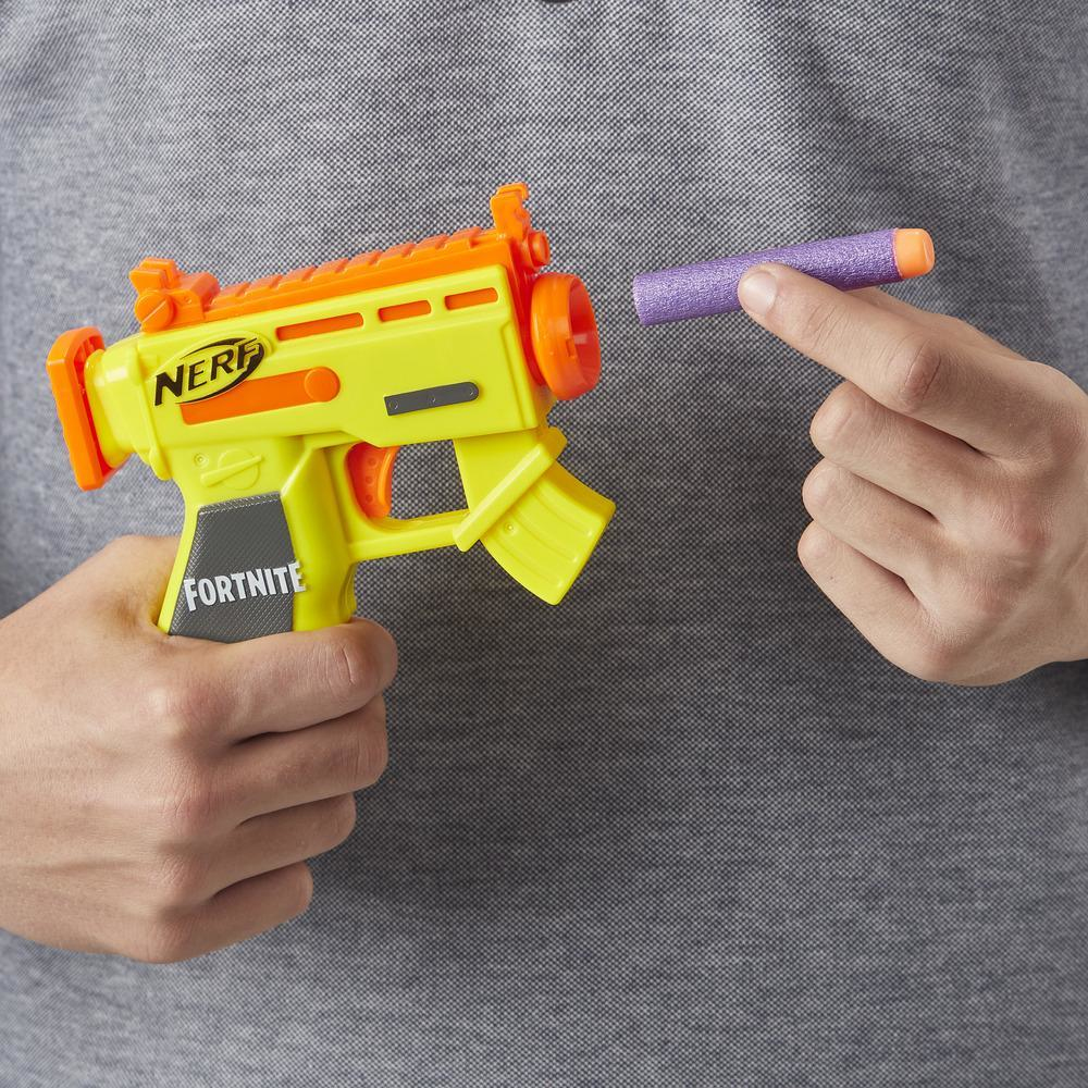 Eine Person hält eine gelb-orangefarbene Nerf-Pistole und einen lila Pfeil.