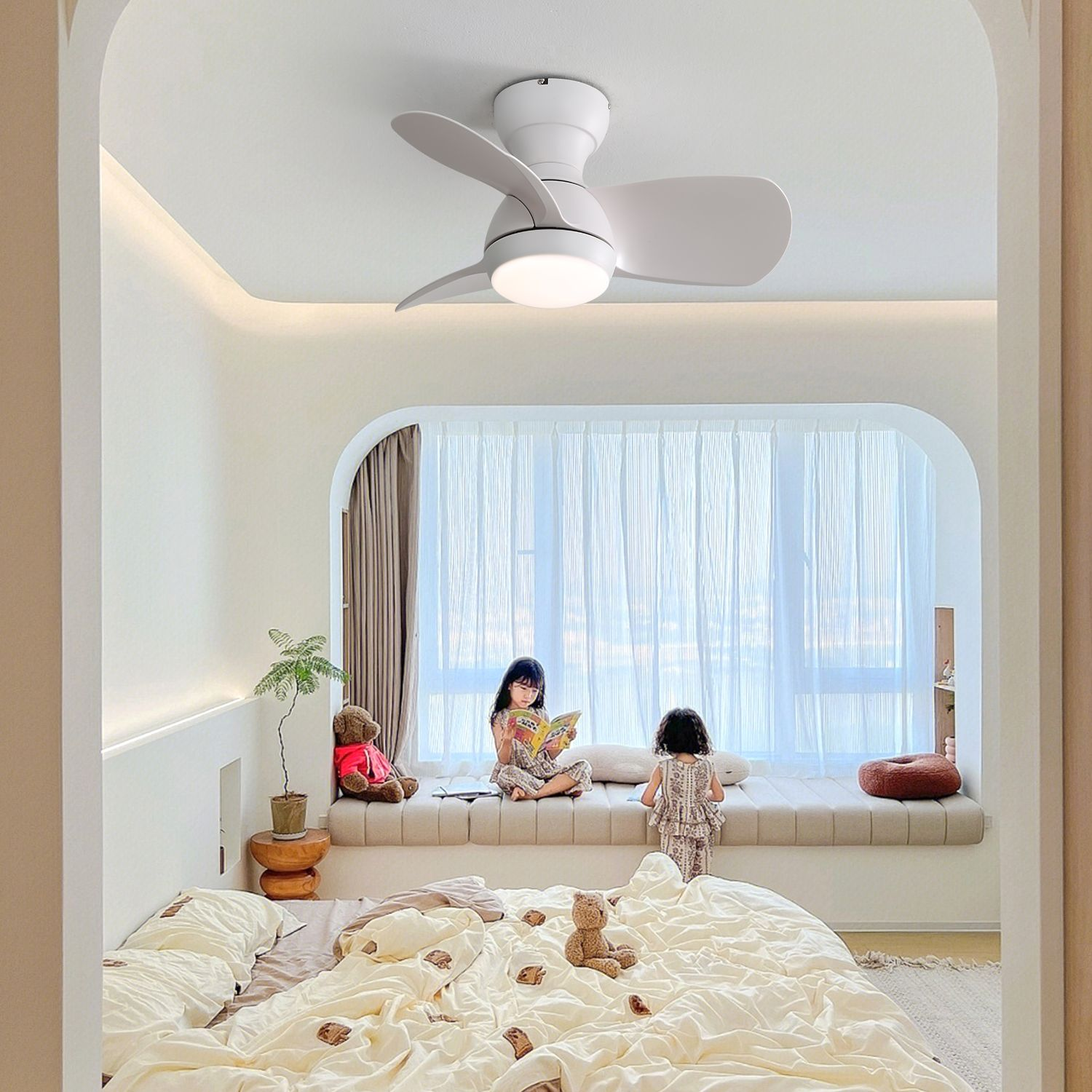 Zwei Kinder lesen auf einer Fensterbank unter einem Deckenventilator in einem hellen Schlafzimmer.