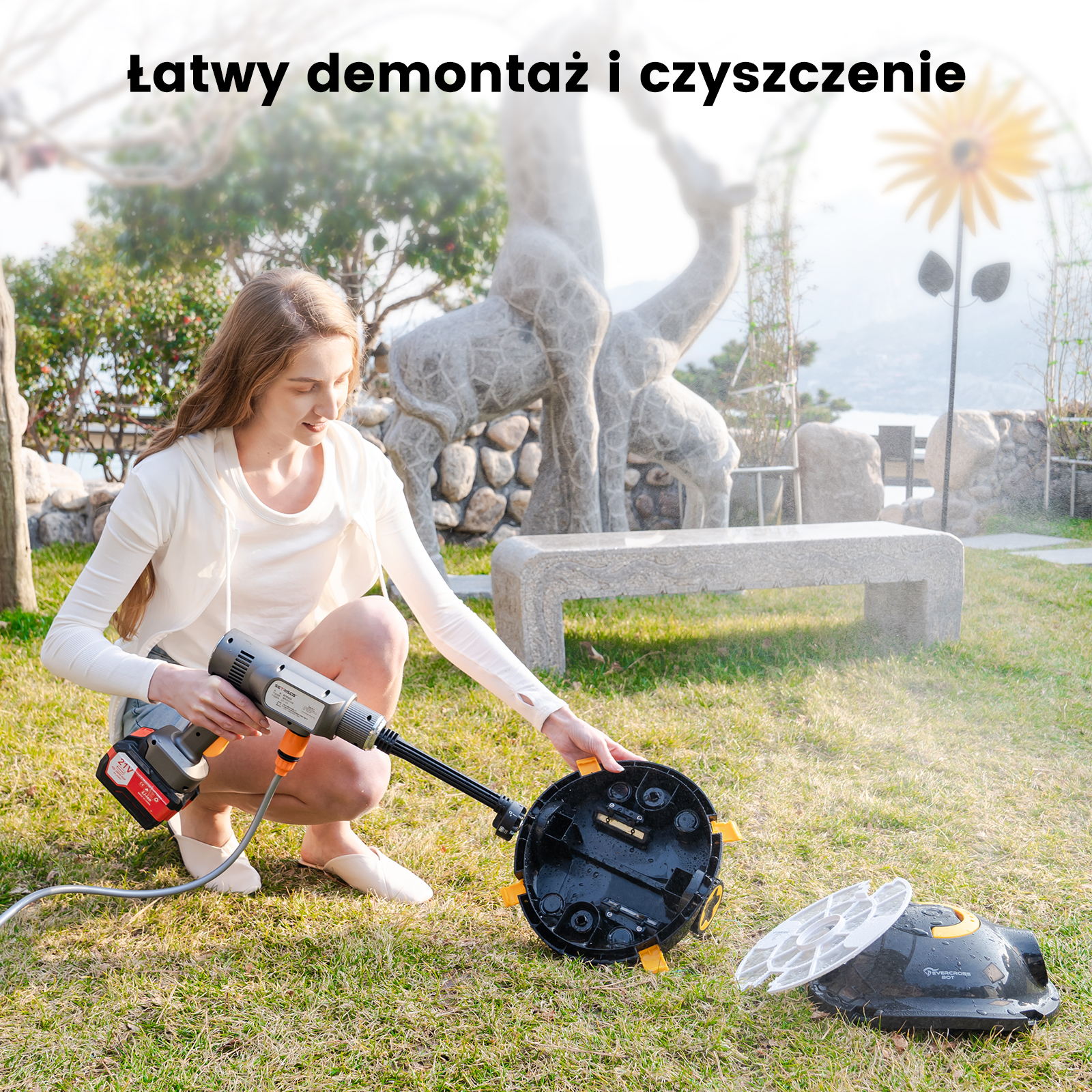 Kobieta klęczy na trawie, demontując odkurzacz basenowy. Jest do niego podłączony wąż.