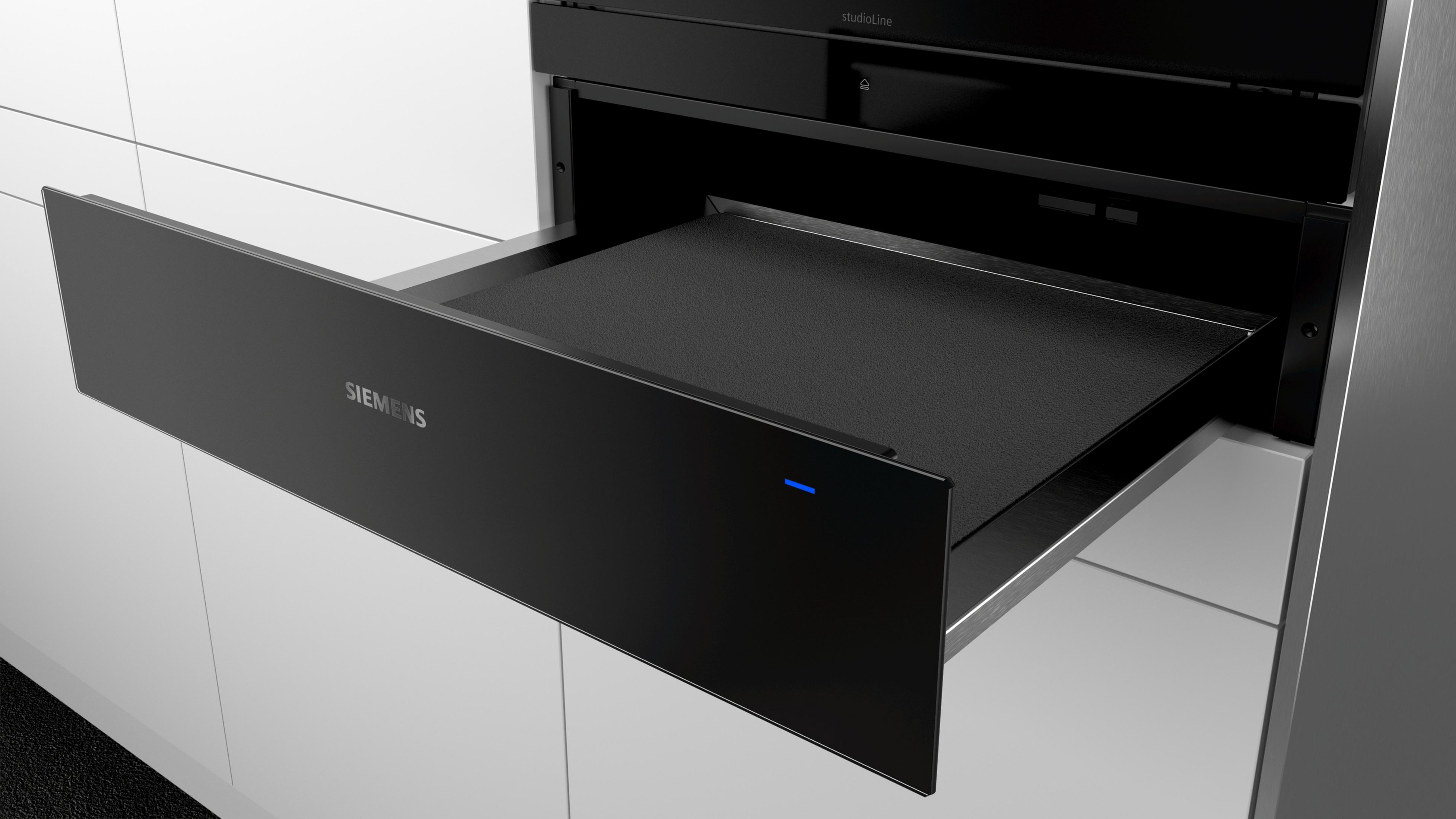 Un forno nero a incasso con un cassetto aperto, una luce blu è accesa.