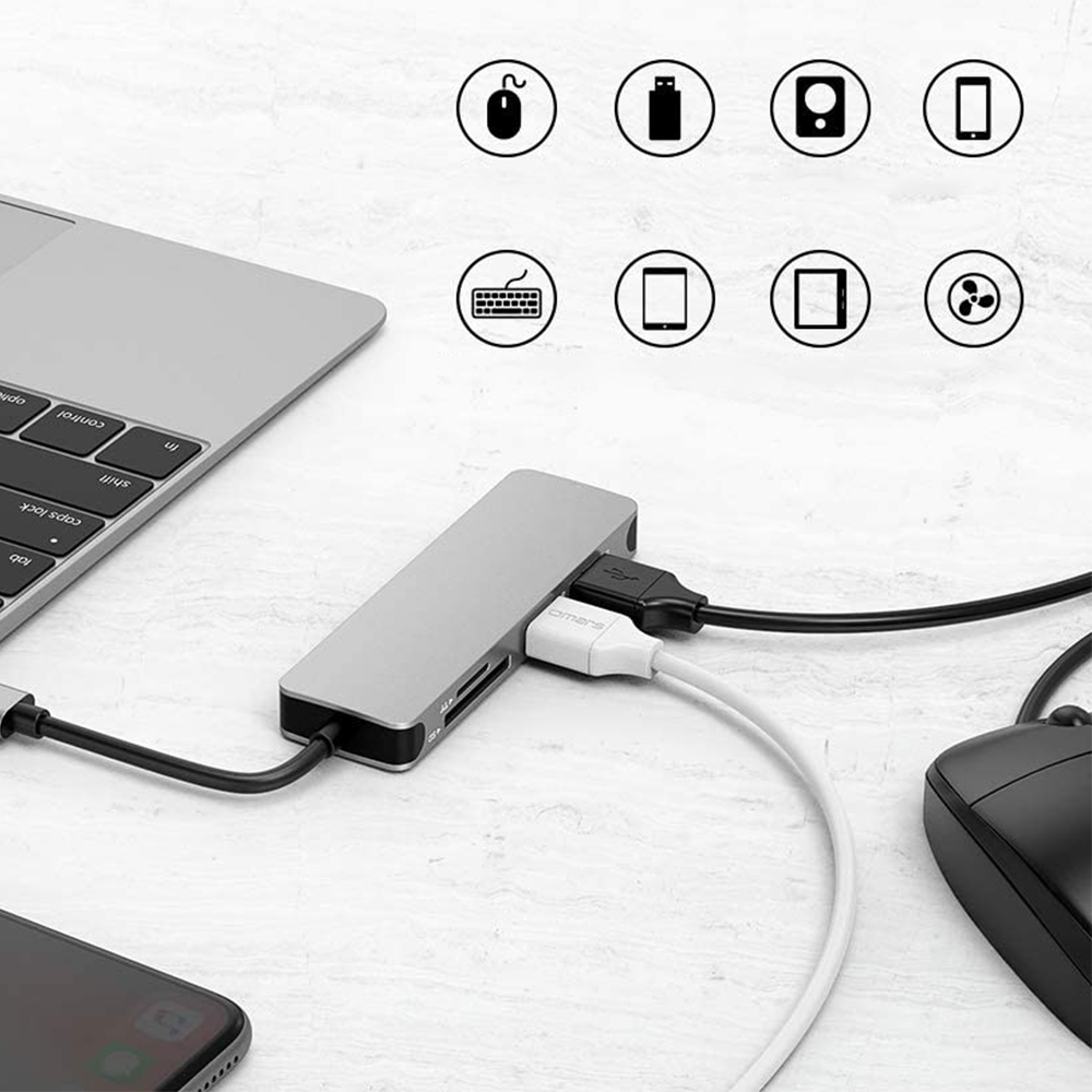 Silberner USB-Hub mit Anschlüssen für verschiedene Geräte, einschließlich Maus, Tastatur und Telefone.