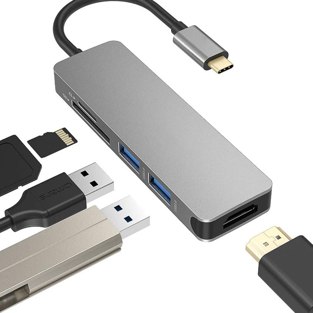 Ein silberner Hub mit mehreren USB-Anschlüssen, SD- und Micro-SD-Kartensteckplätzen sowie USB-C- und HDMI-Anschlüssen, mit Kabeln.